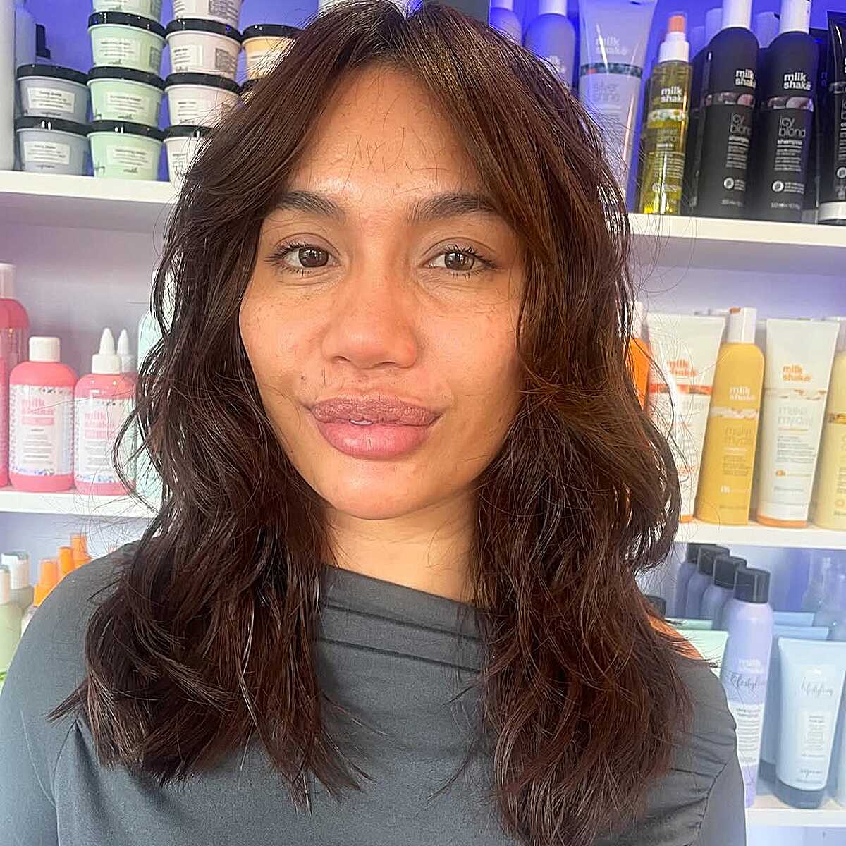 Medium chestnut brown wavy wolf cut with curtain bangs
