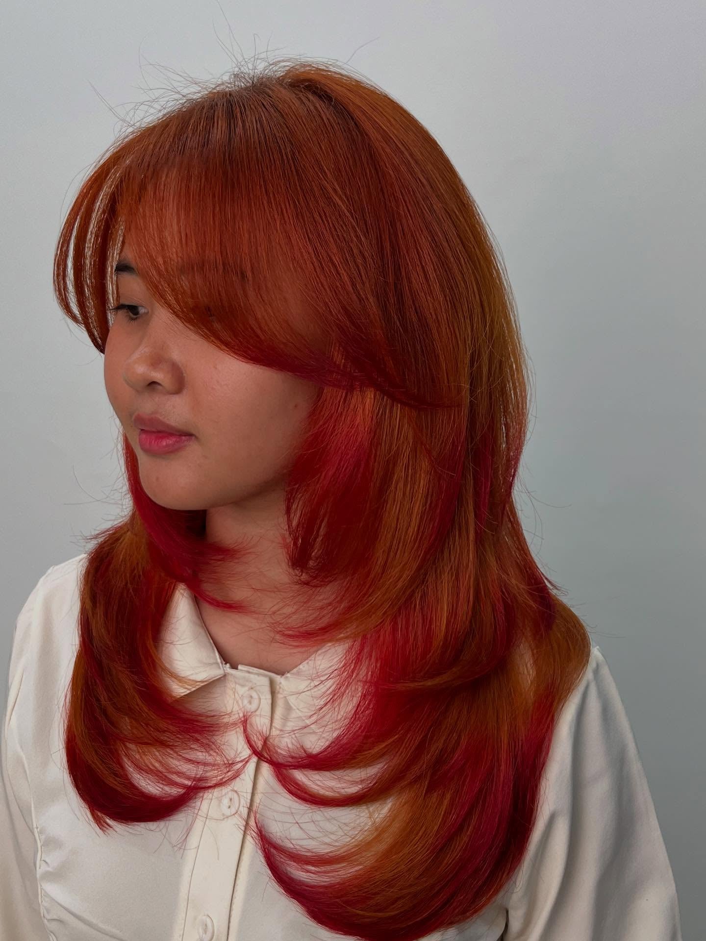 Copper and red two-tone layered wolf cut with bangs