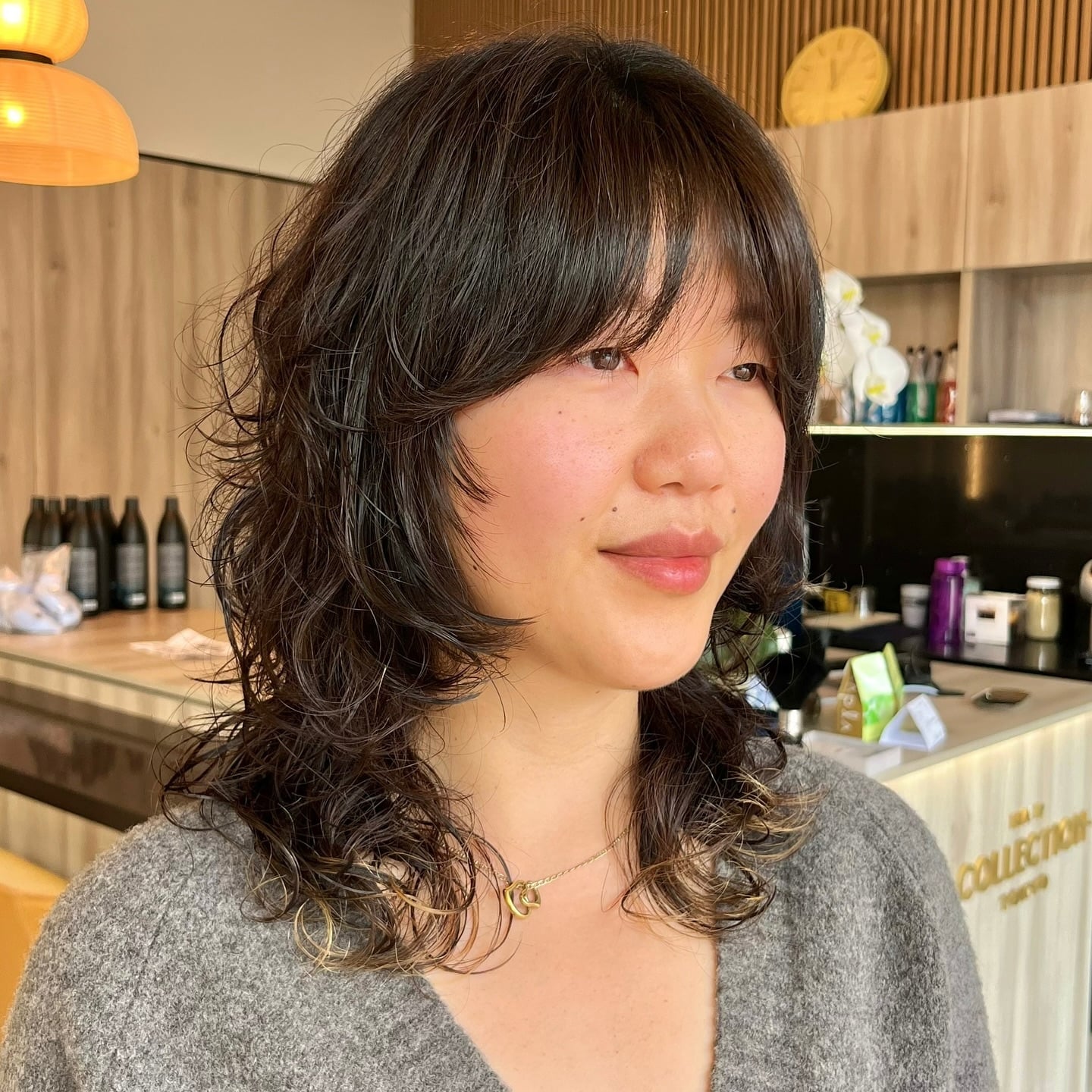 Medium curly dark wolf cut with curtain bangs