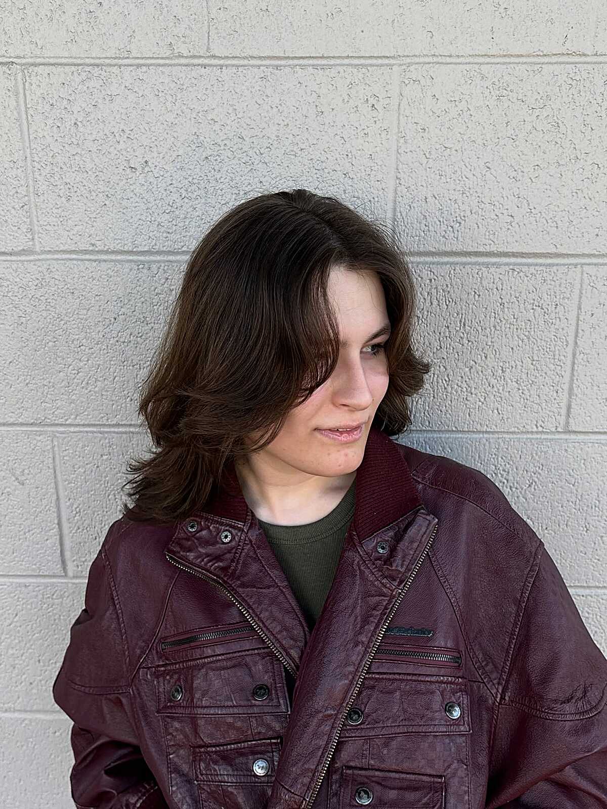 Short wavy brunette wolf cut with side-swept bangs