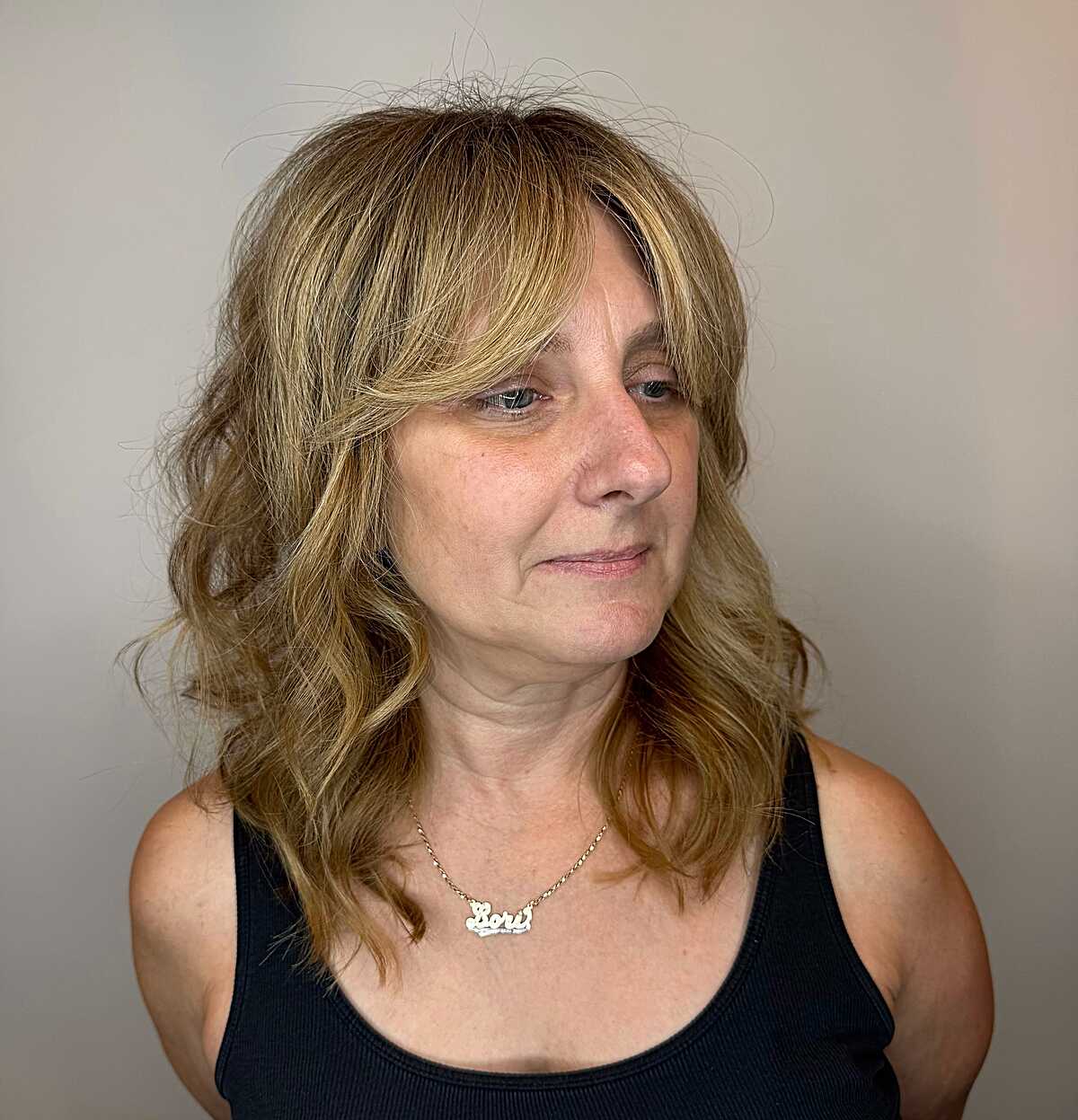 Warm blonde wavy wolf cut on mature woman with bangs