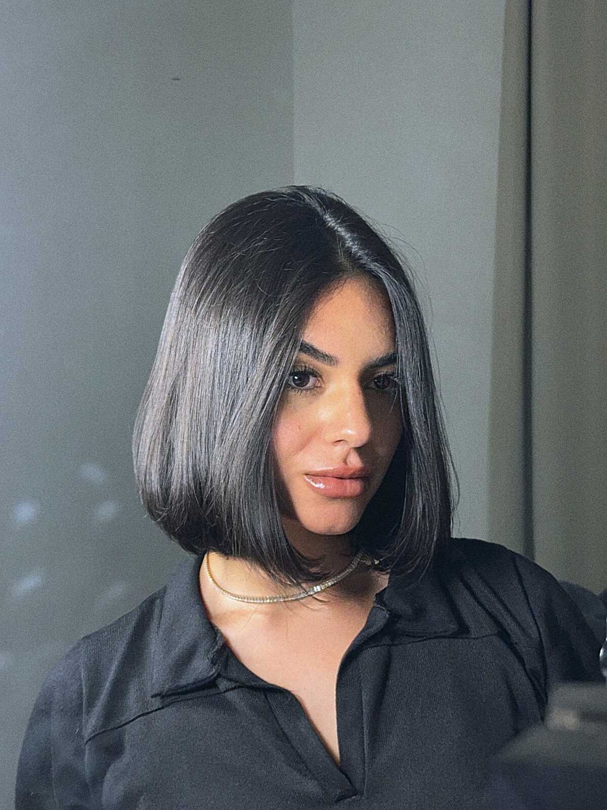 Sleek glossy black bob with center part at chin length