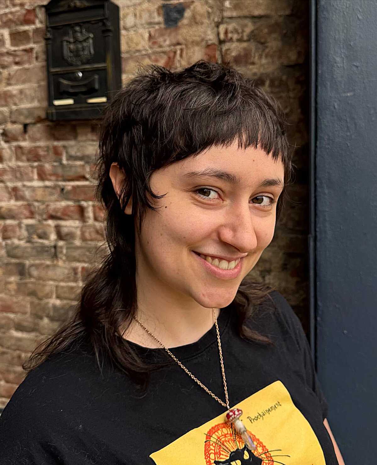 Choppy dark brown short mullet with baby bangs