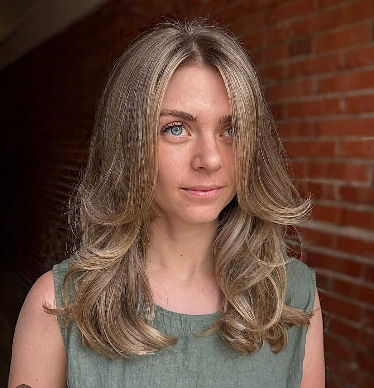 Long sandy blonde hair with feathered layered ends