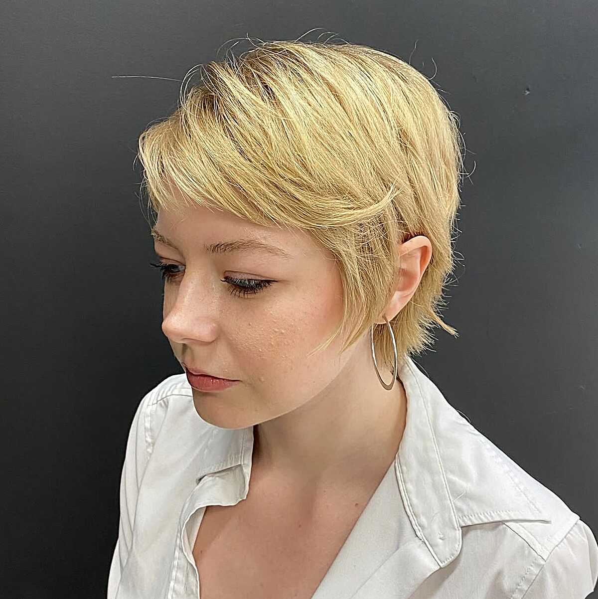 Short honey blonde pixie with feathered layers at sides