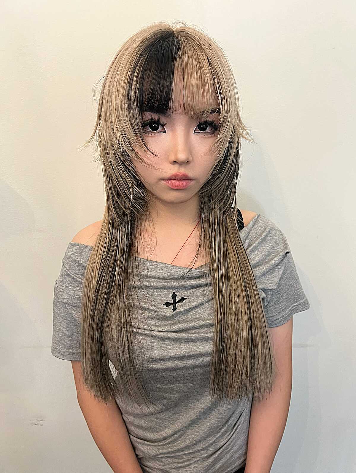 Ash blonde jellyfish with wispy layers and dark roots