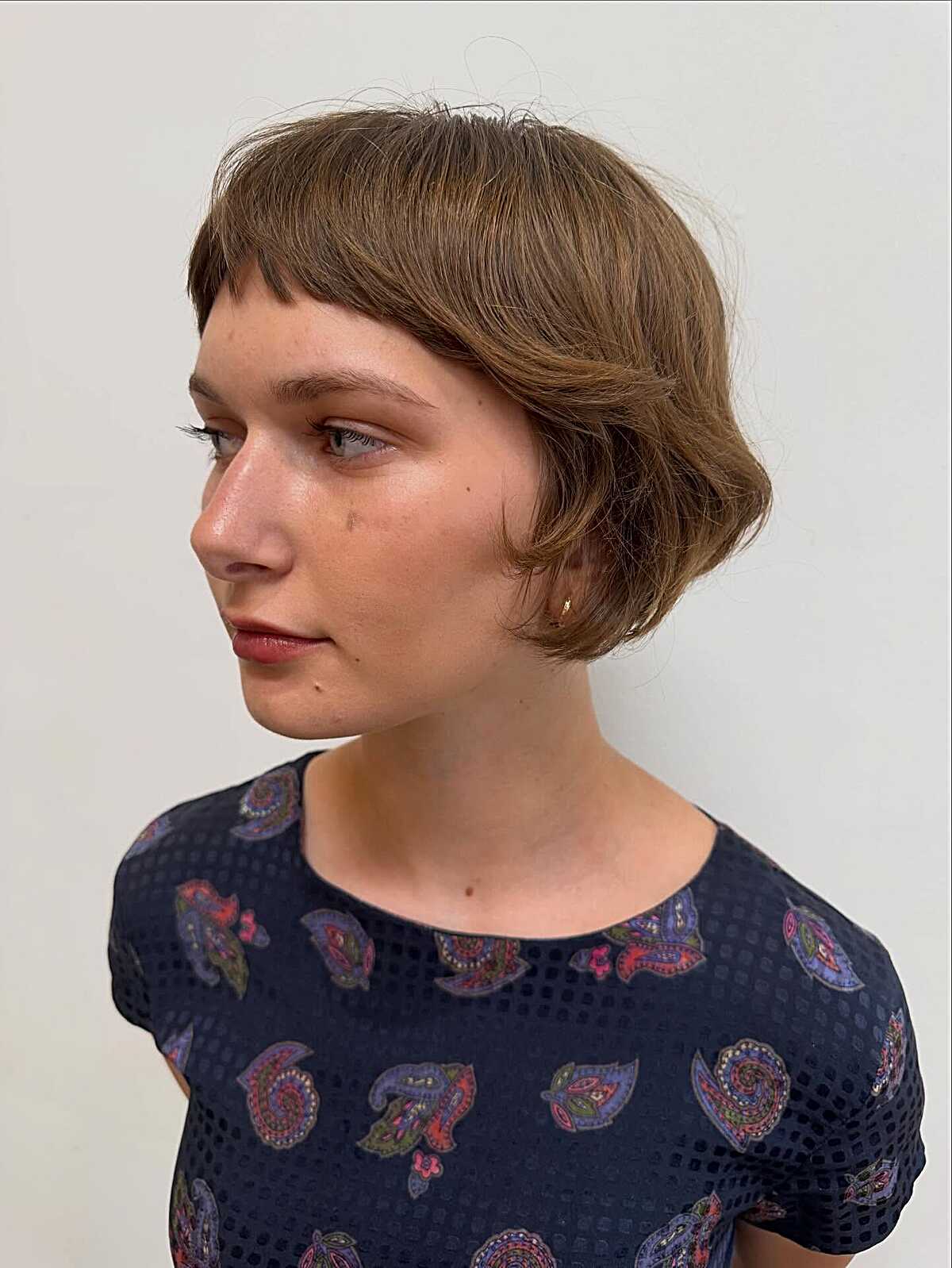 Short rounded brown crop with curved micro bangs