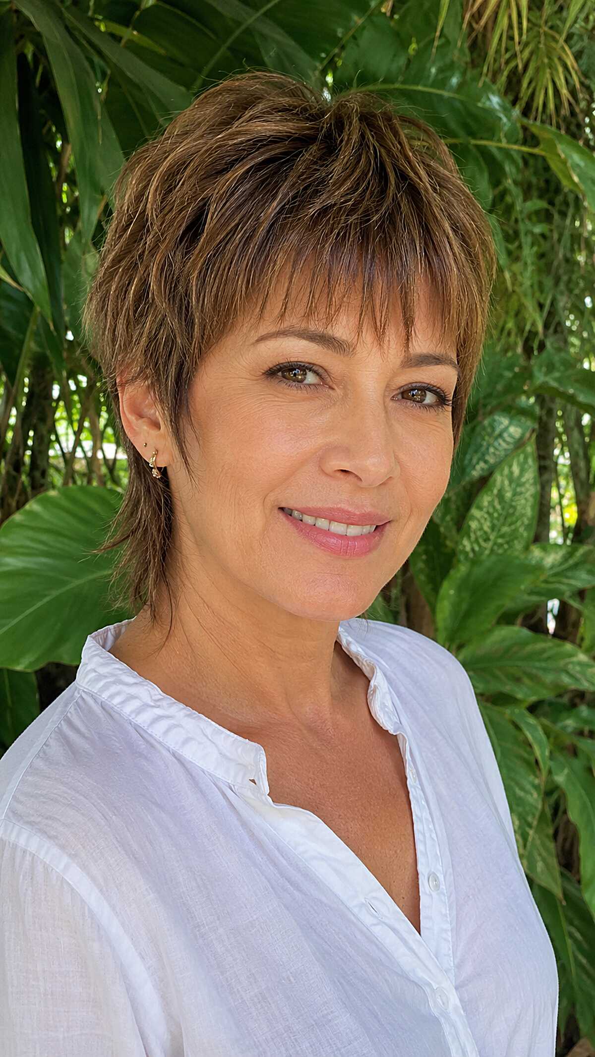 Sun-streaked brunette layered mixie with wispy pieces