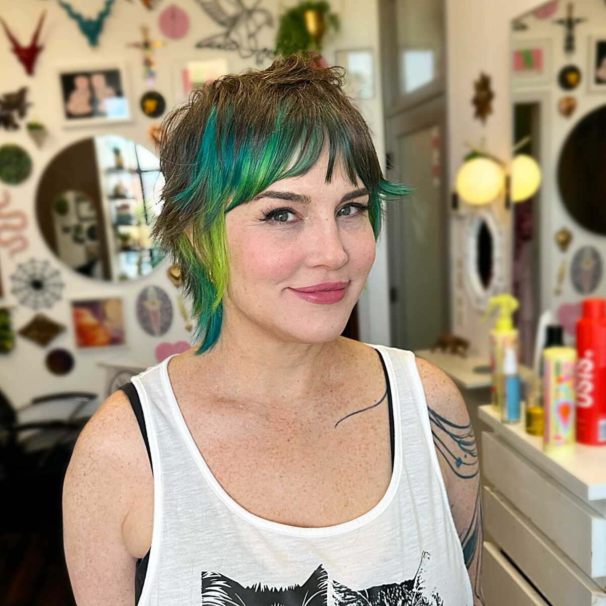 Short brunette mullet with teal green streaks