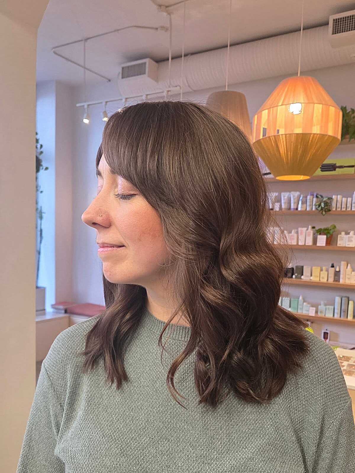 Medium-length brunette waves with soft wispy bangs