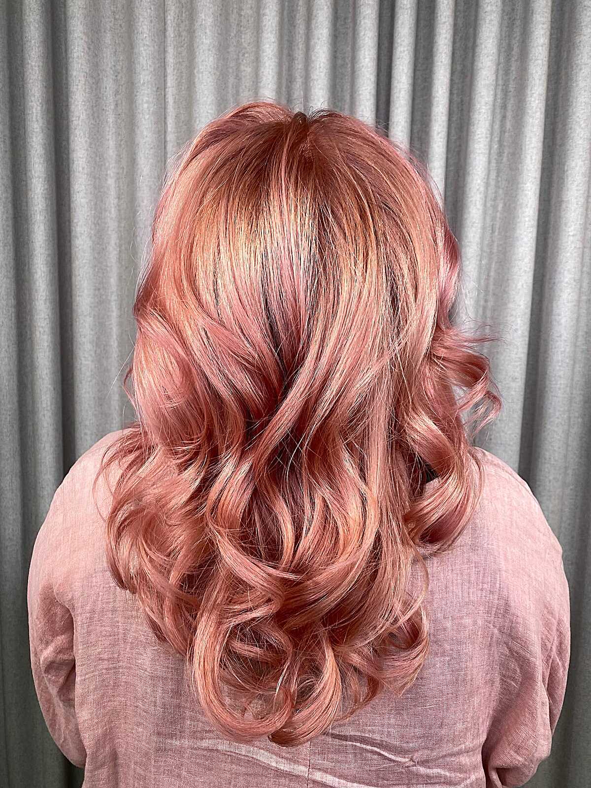 Medium rose gold hair styled in soft vintage curls