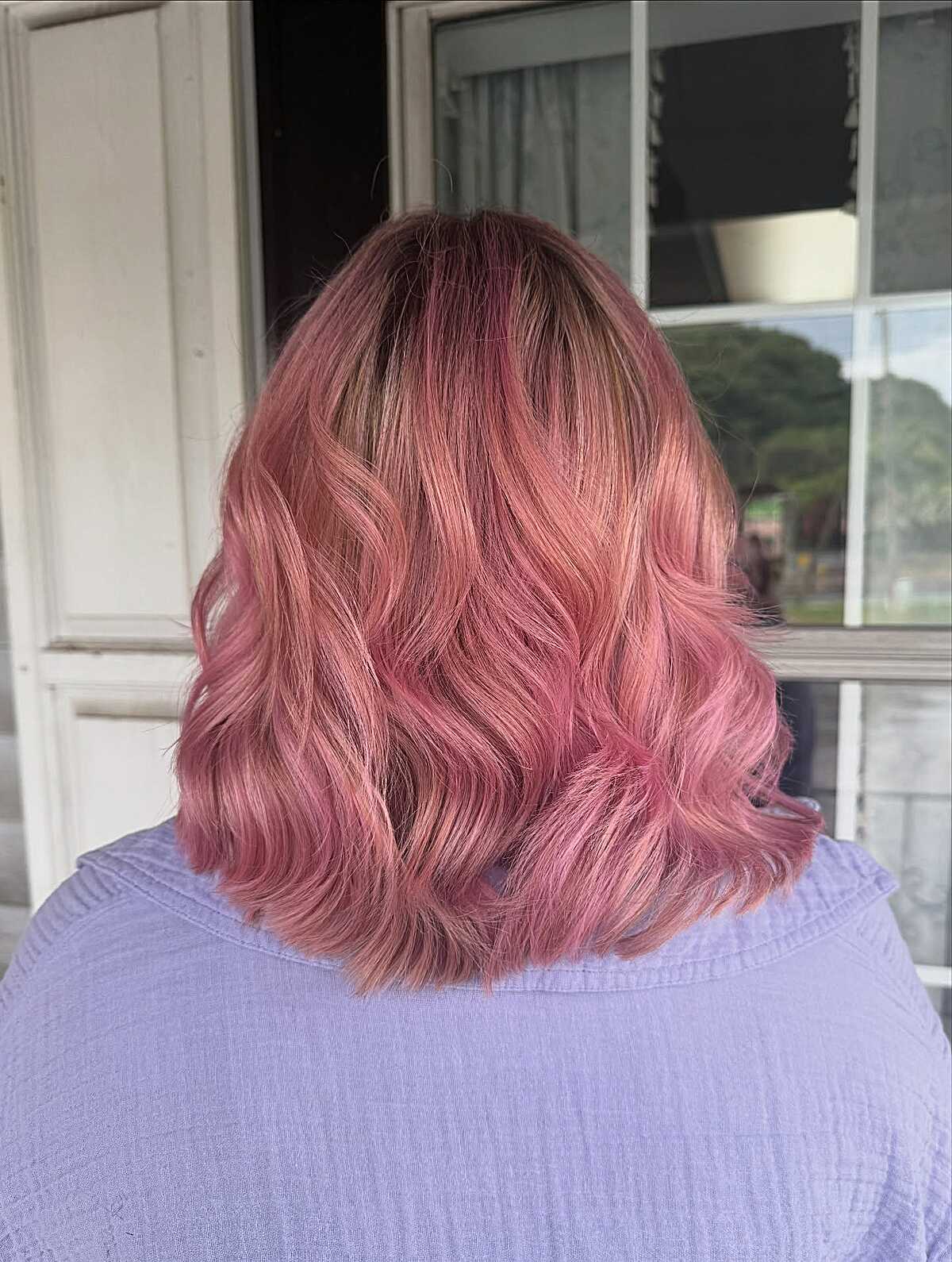 Short rosy peach wavy bob with dark roots