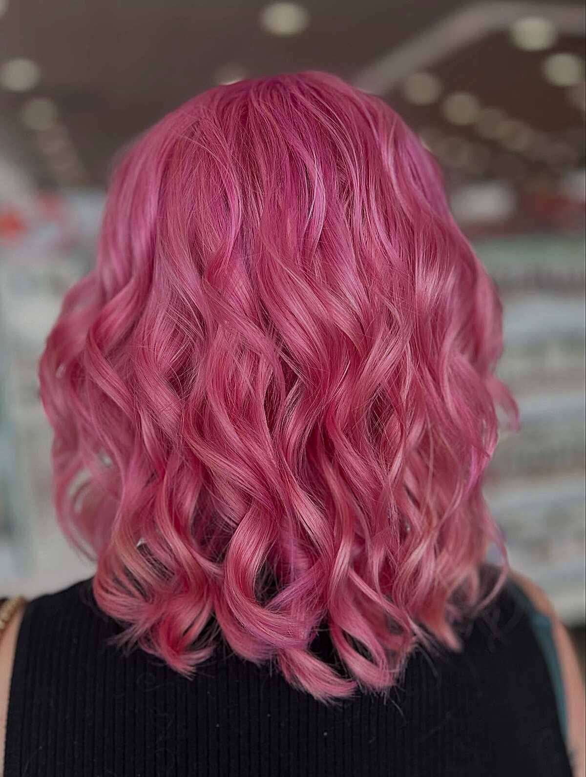 Saturated rose pink hair with tight spiral waves