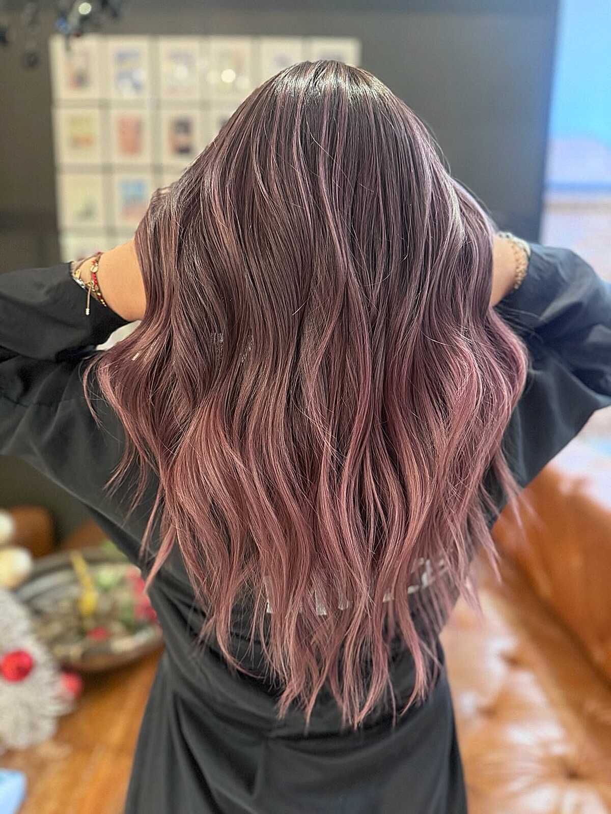 Smoky plum to pink balayage on long wavy dark hair