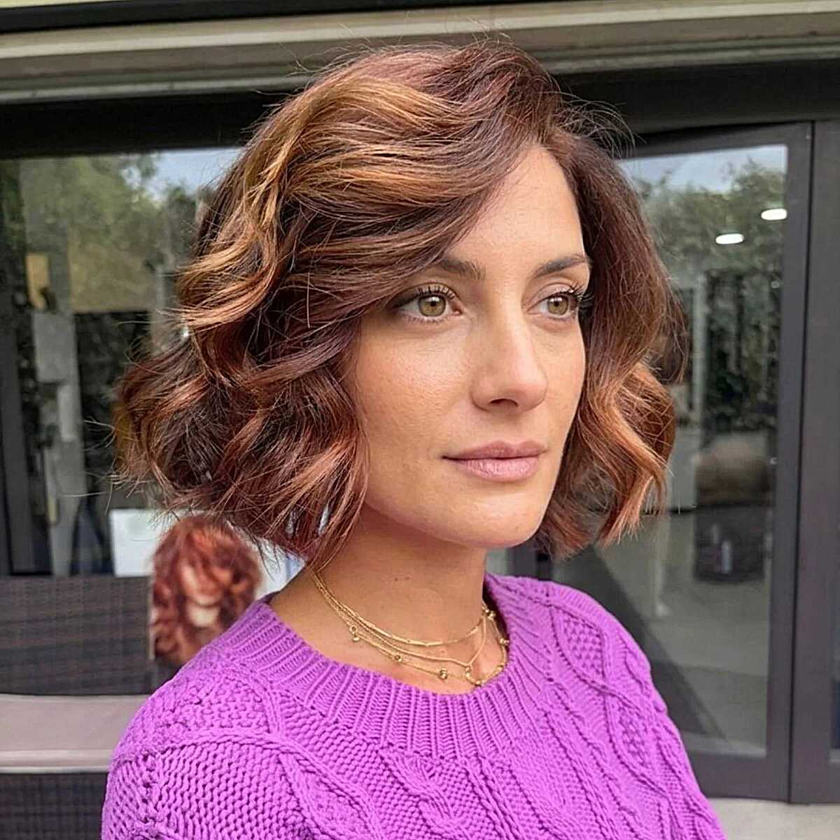Wavy coppery auburn bob with warm highlights