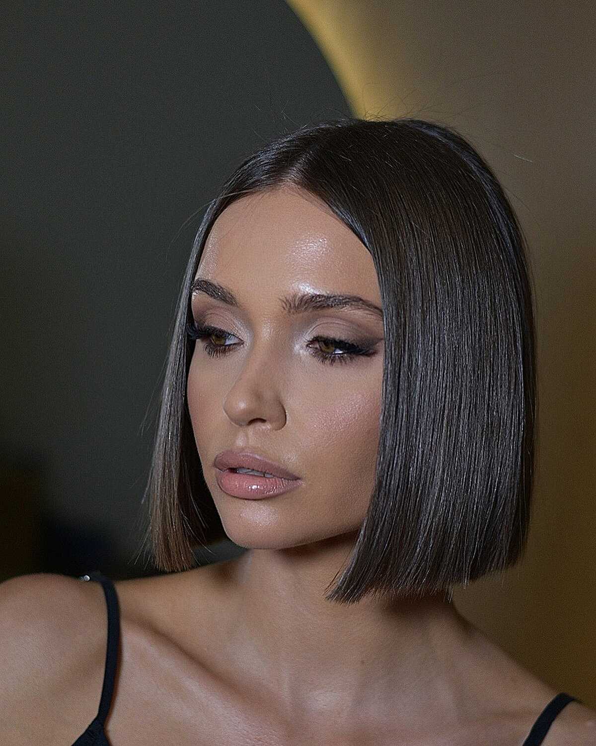 Sleek dark brown glass-finish bob below the chin