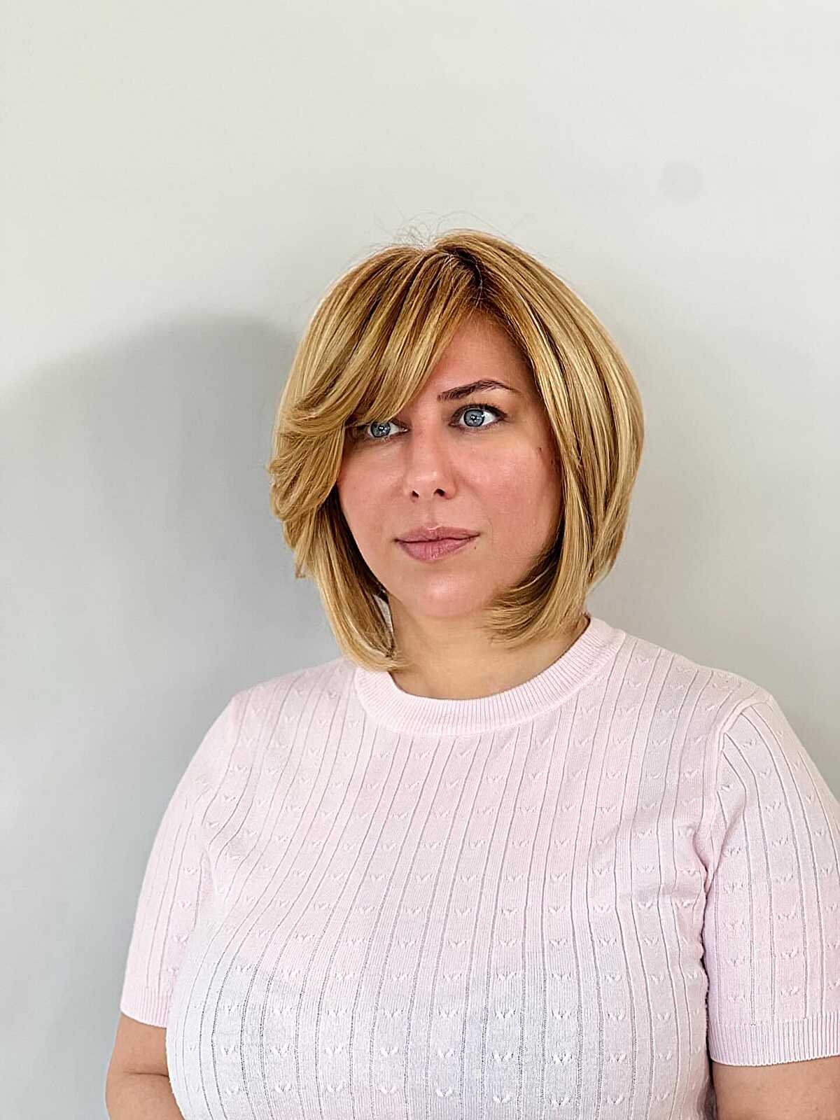 Golden honey blonde layered bob with curtain bangs