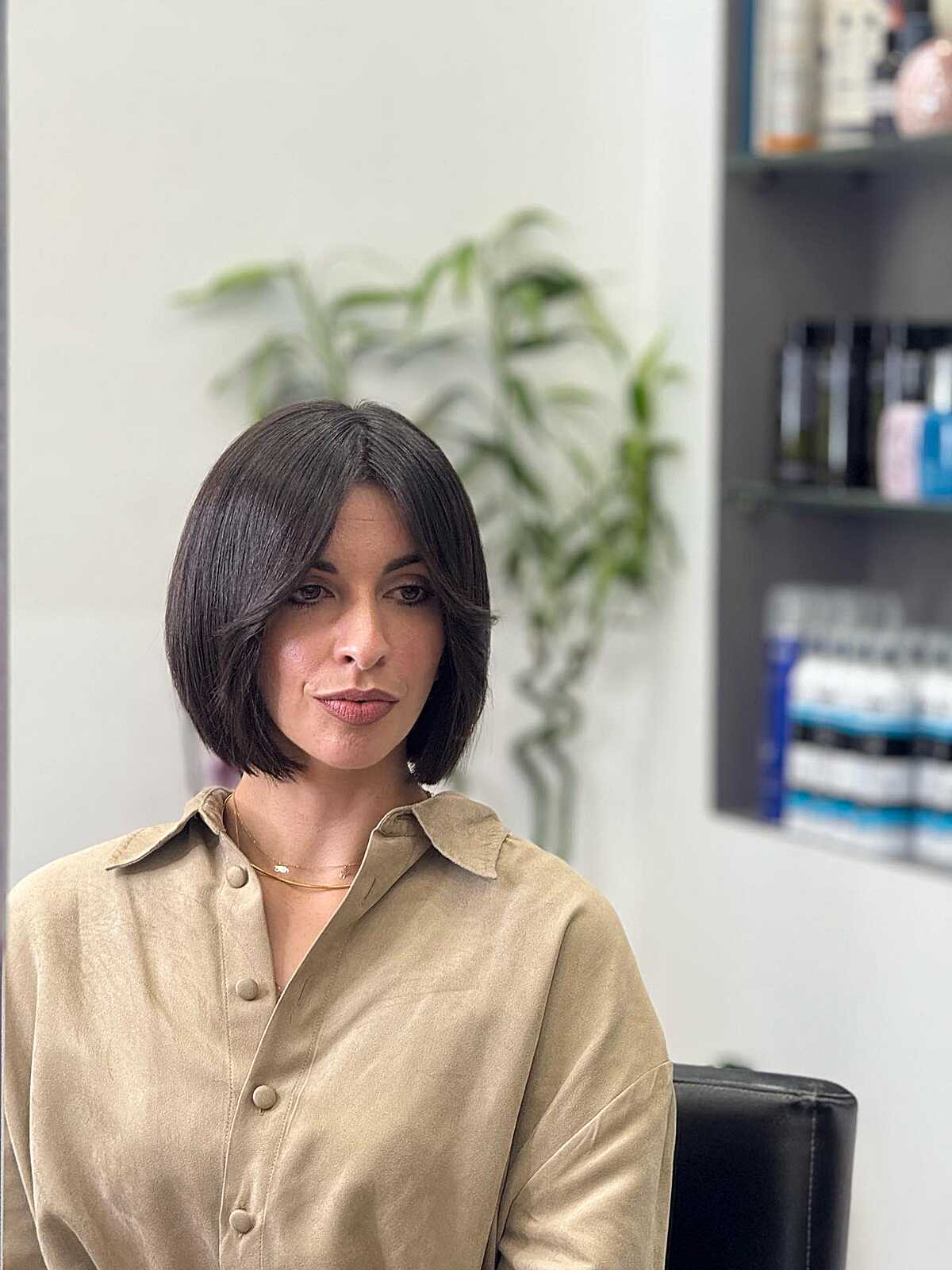 Polished dark brunette bob with wispy side-parted bangs