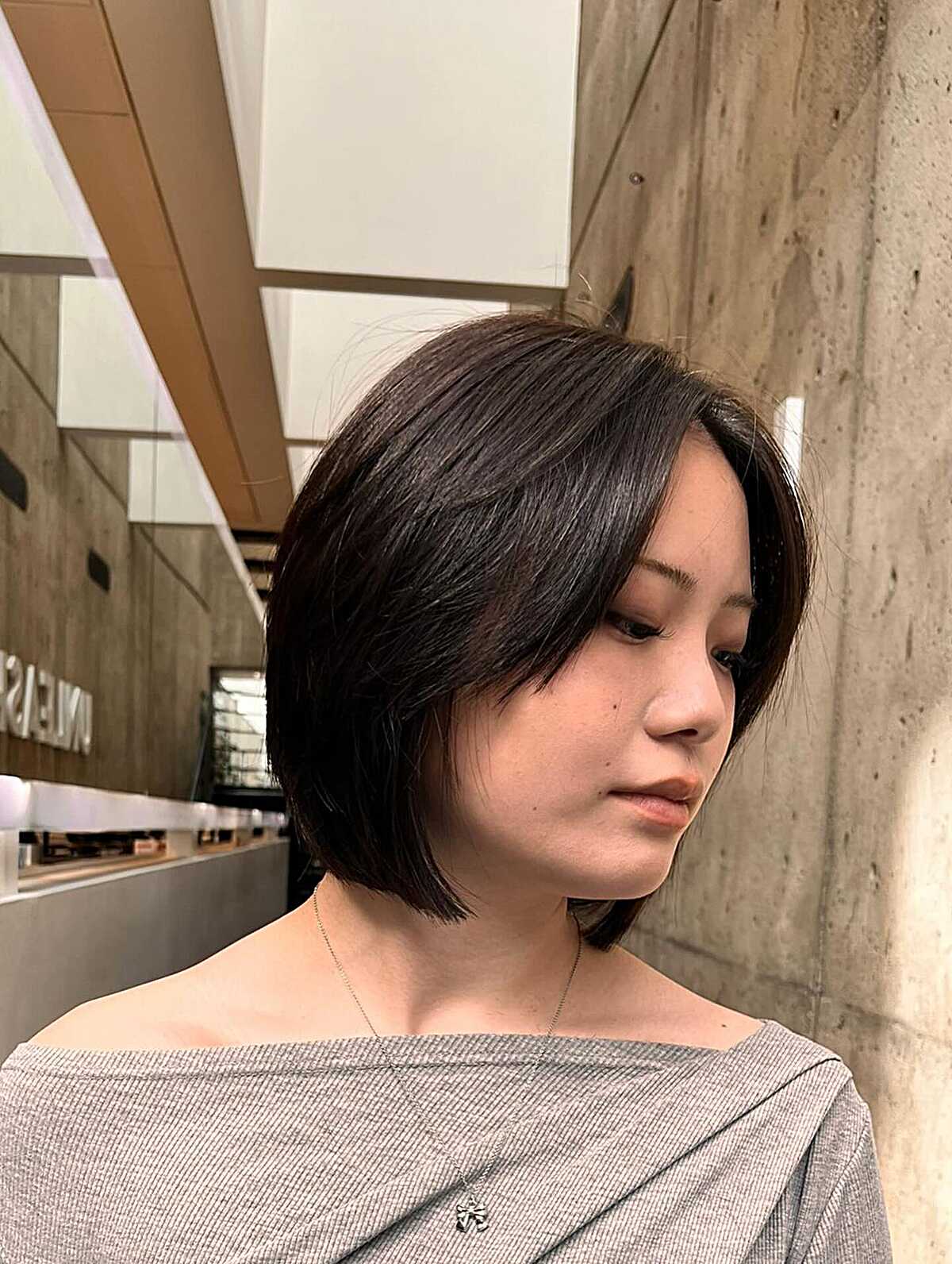 Tapered dark brown bob with swooping side layers