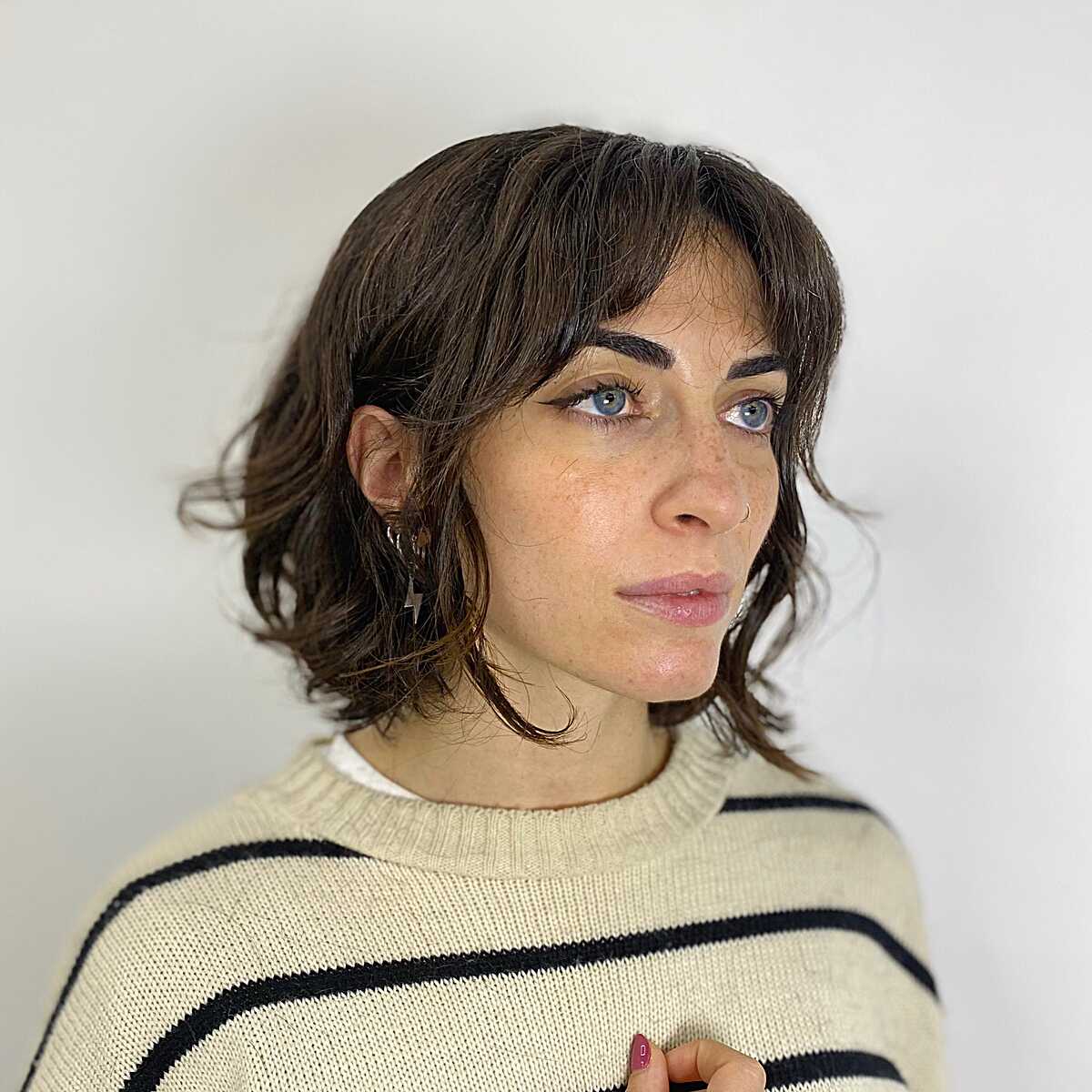 Wavy dark brown bob with wispy curtain bangs