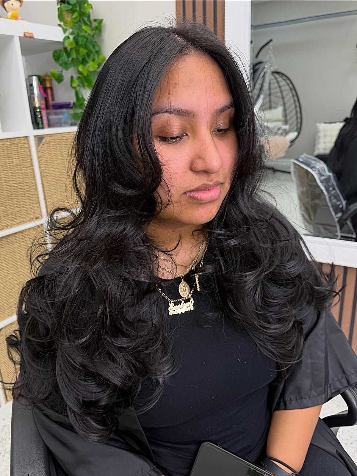 Black hair with curled face framing layers and deep part