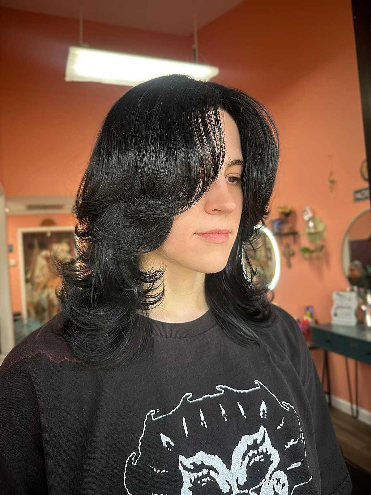 Medium black hair with curly layered shag and side sweep