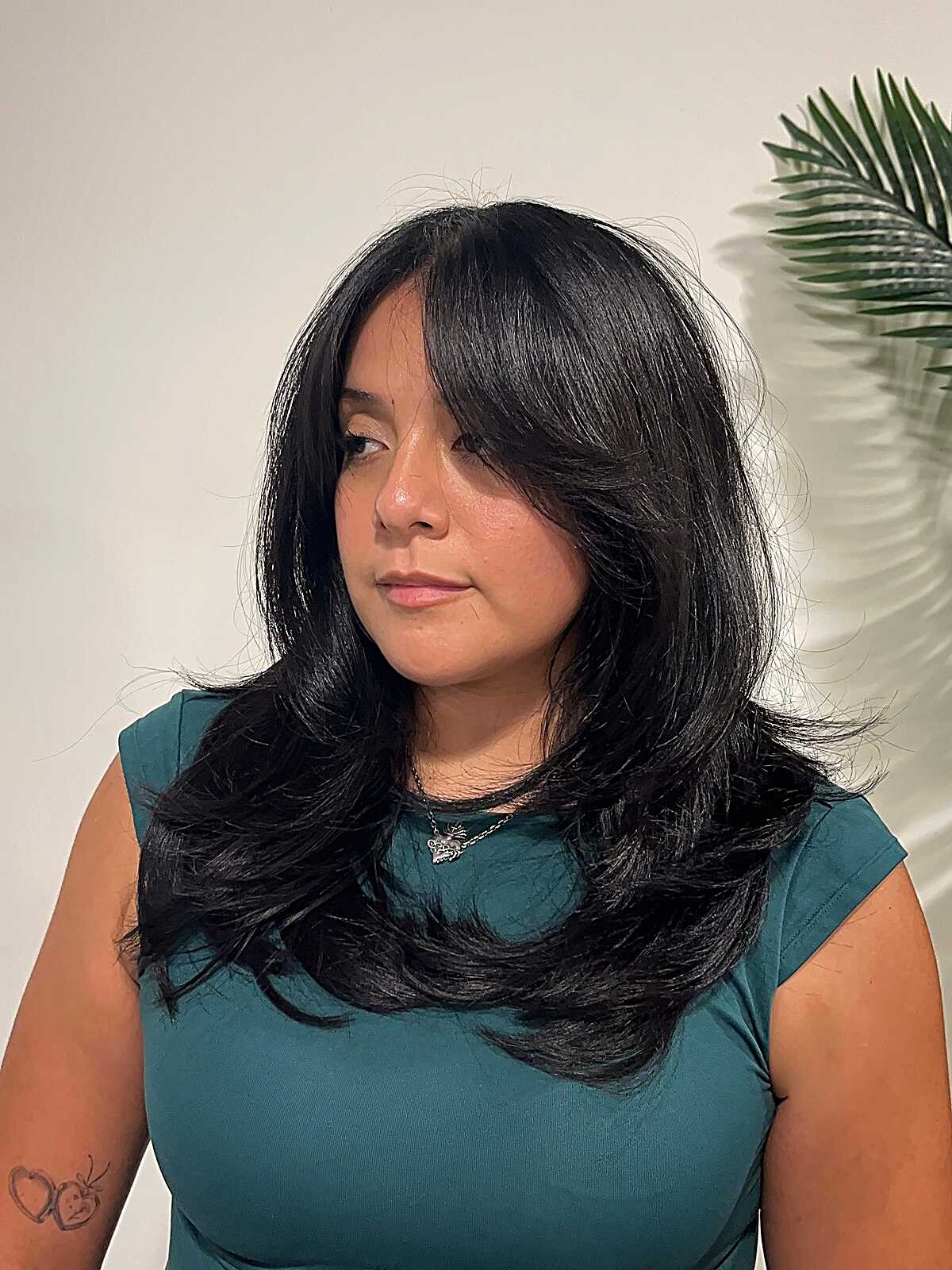 Medium-long black hair with feathered face framing layers