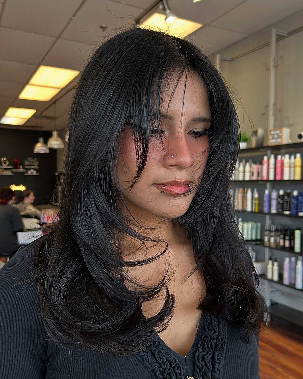 Black hair with lived-in layers and wispy curtain bangs