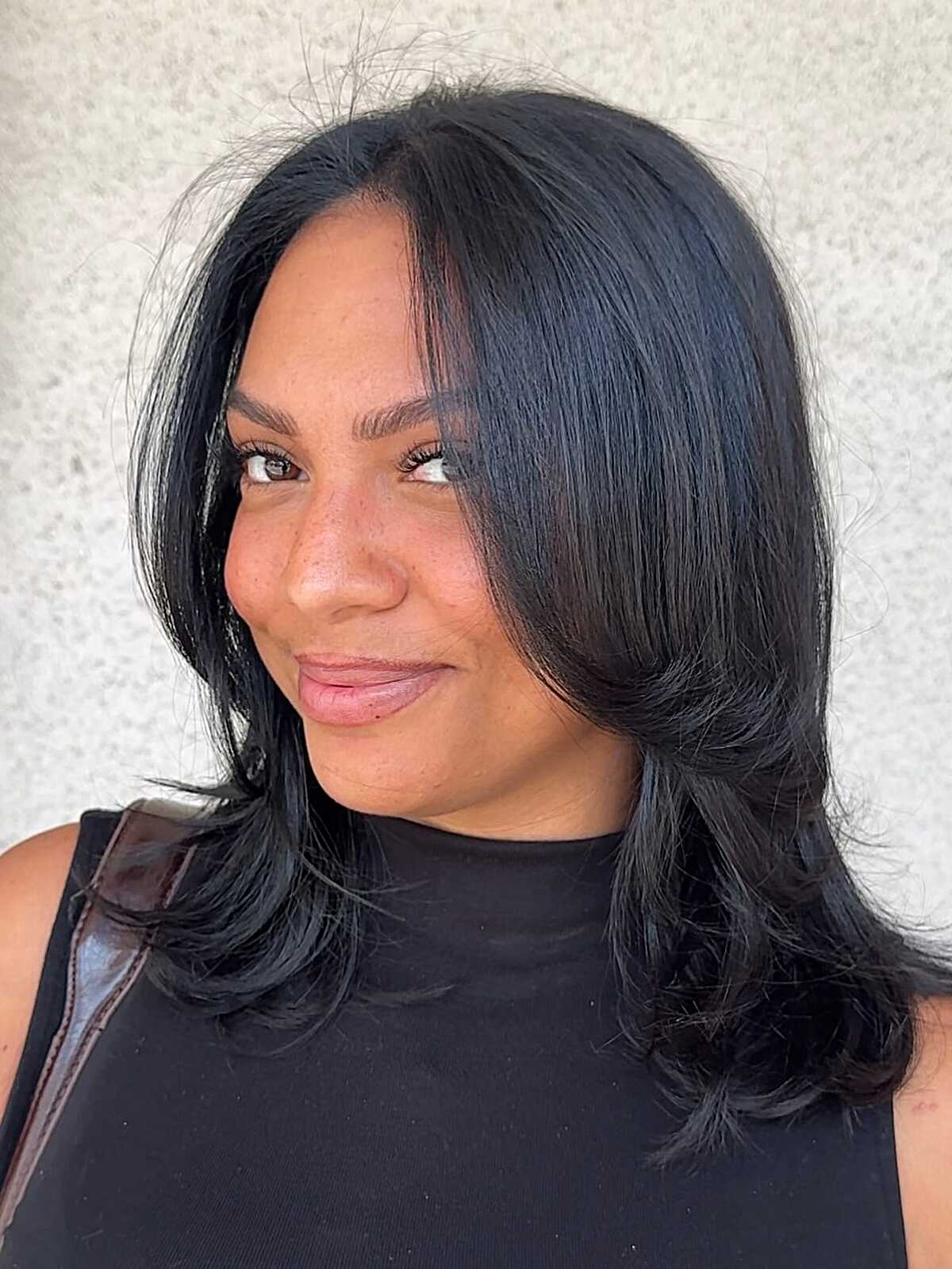 Medium length polished black hair with flipped layers