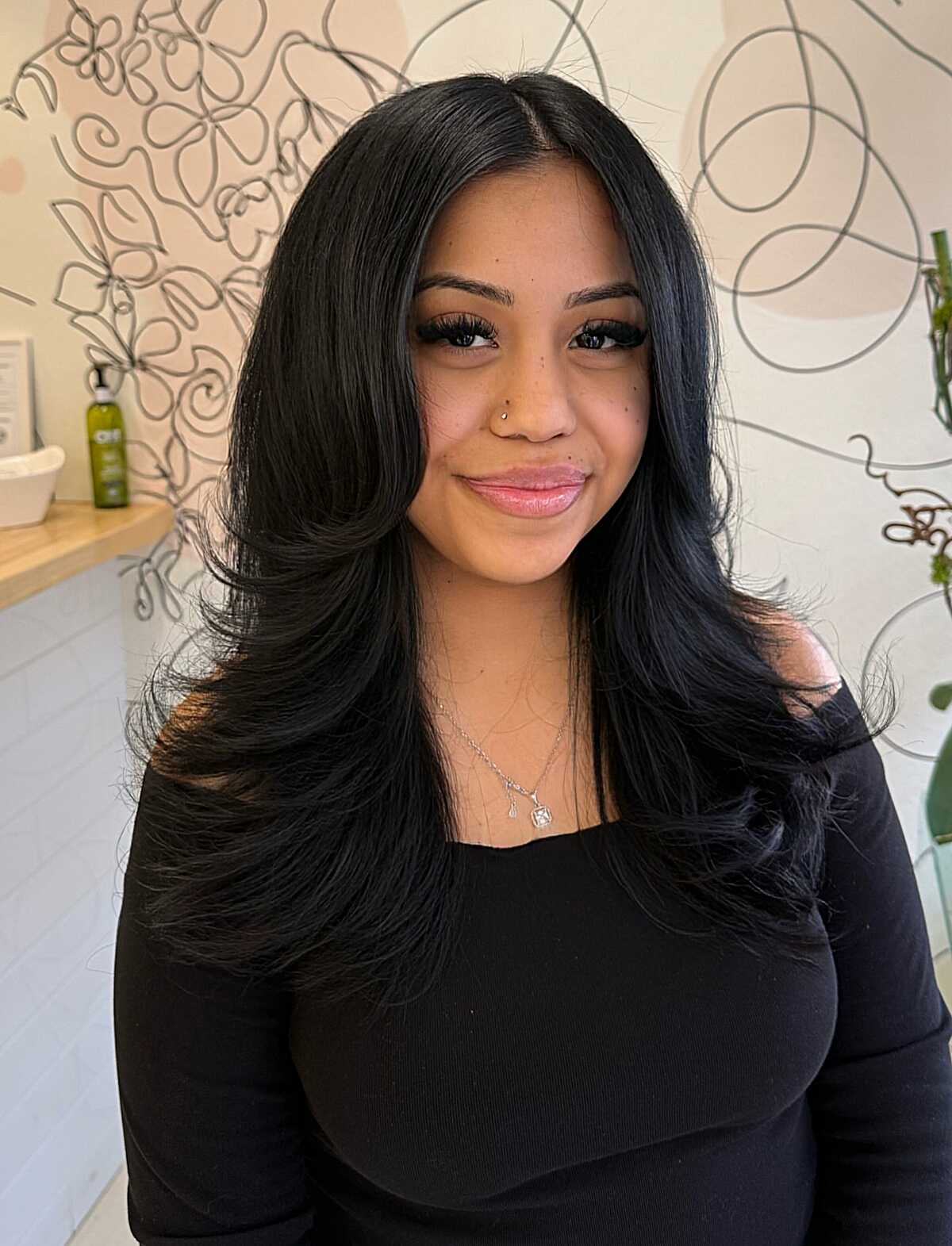 Black hair with voluminous face framing layers and blowout