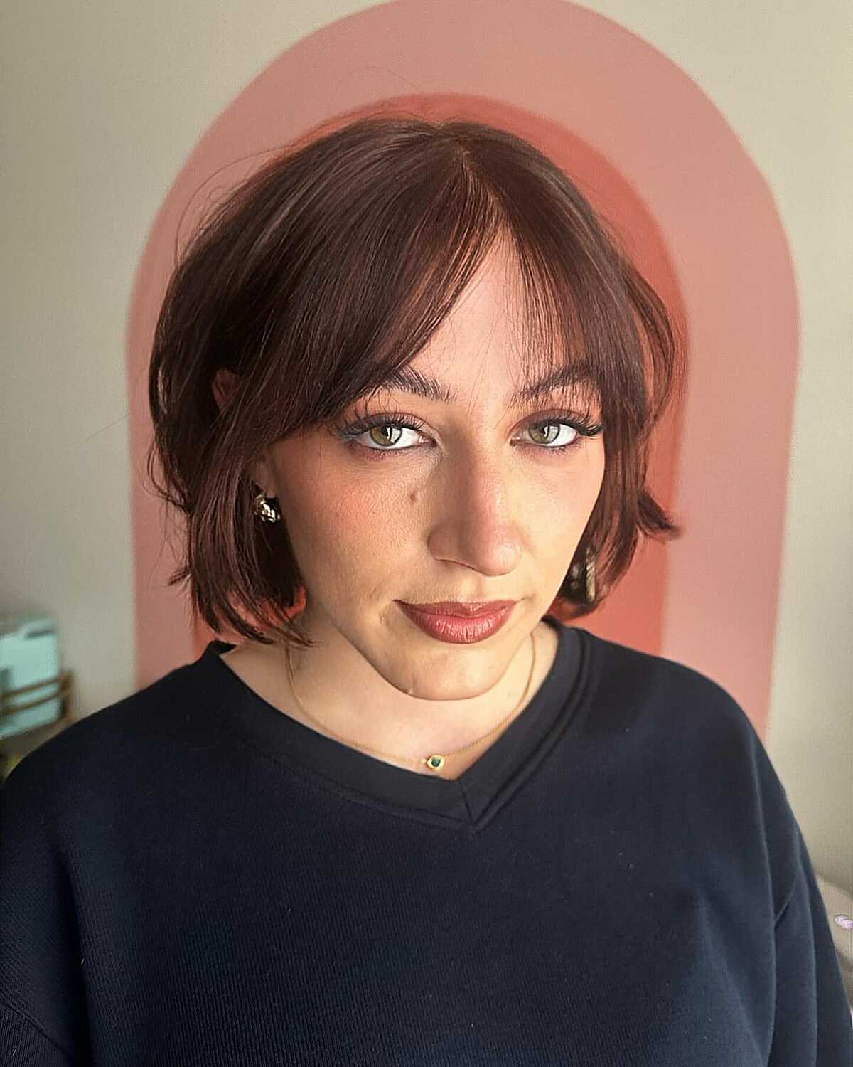 Auburn-toned chin-length cowgirl bob with curtain bangs