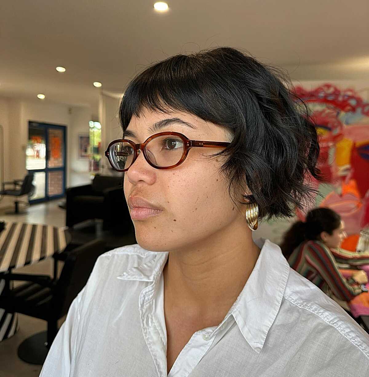 Cropped black cowgirl bob with baby bangs and glasses
