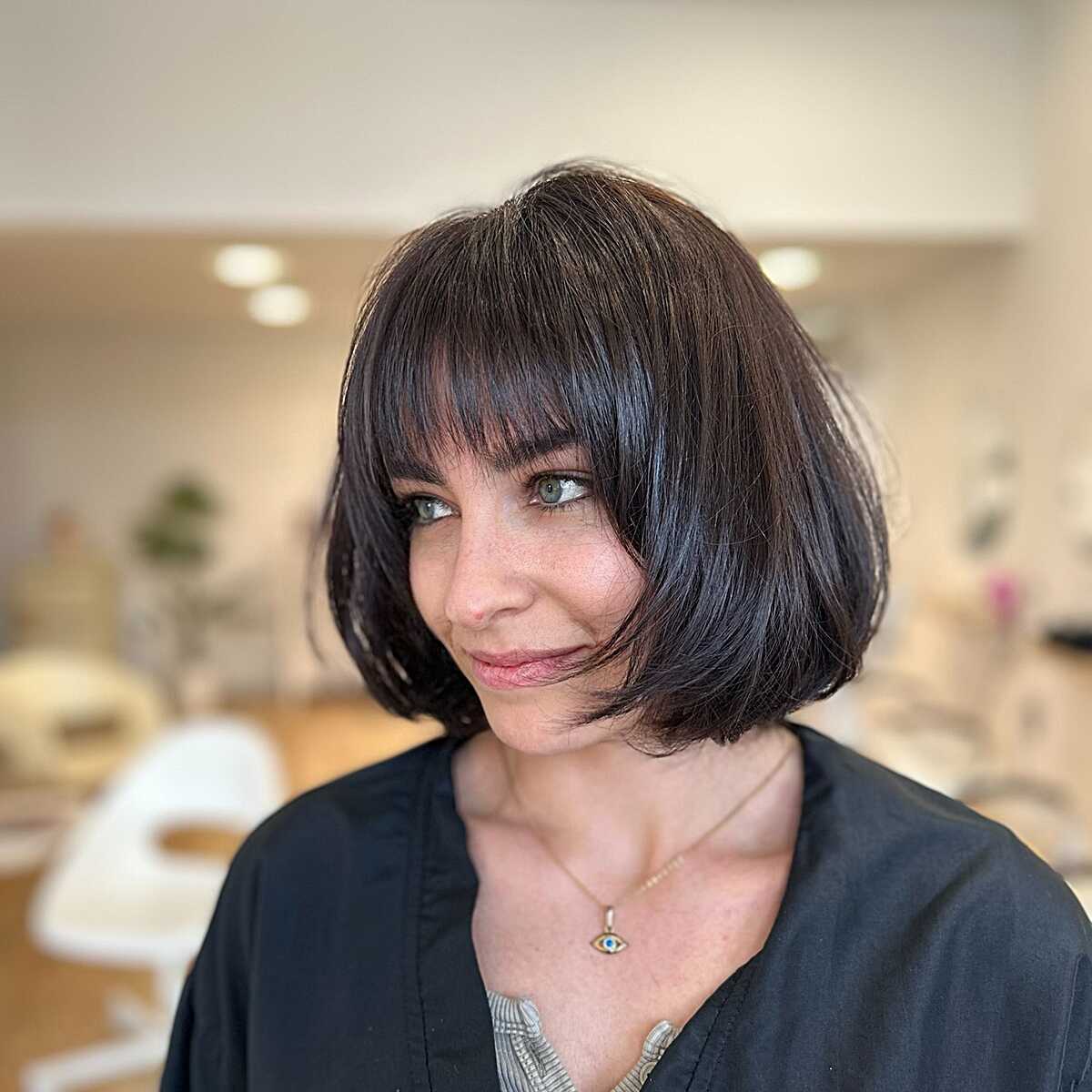 Polished dark chin-length bob with full bangs