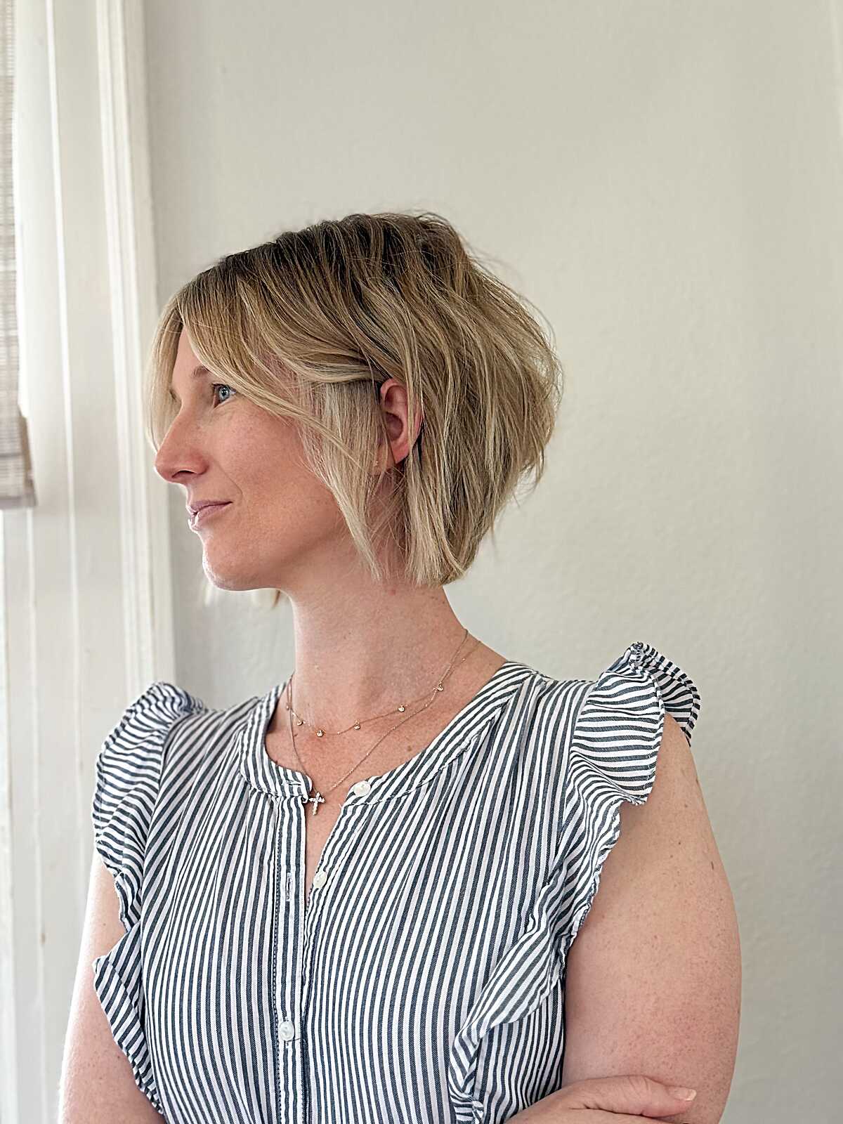 Side profile of sun-kissed blonde stacked cowgirl bob