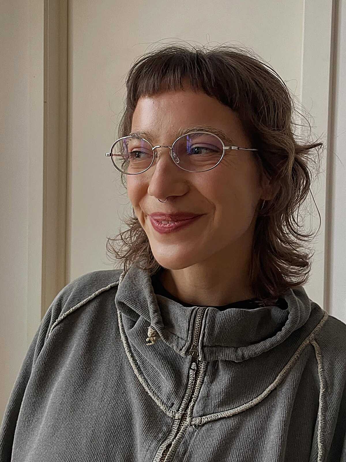 Short brown curly shag with glasses and micro bangs