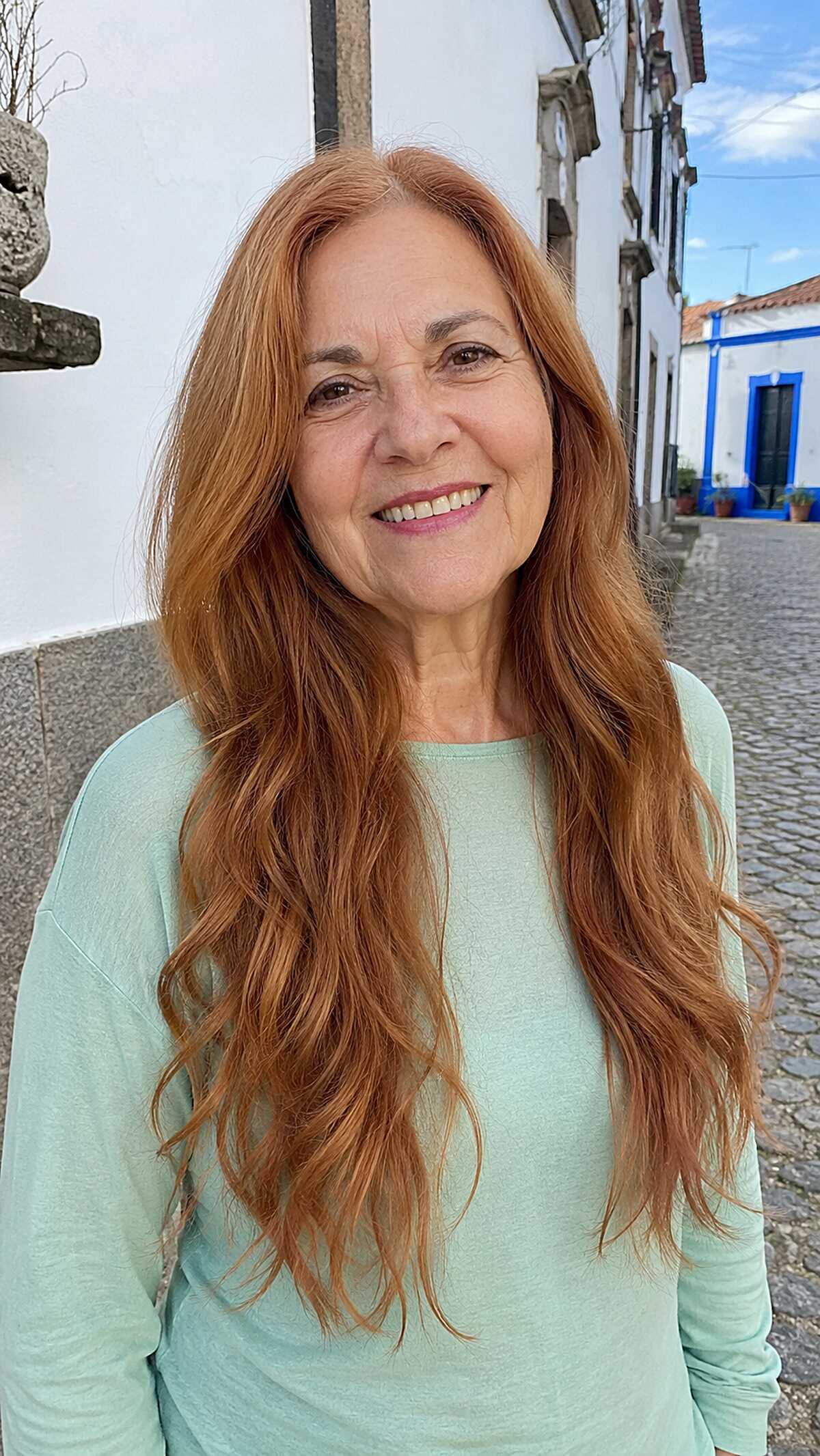 Long warm copper wavy hair on an older woman