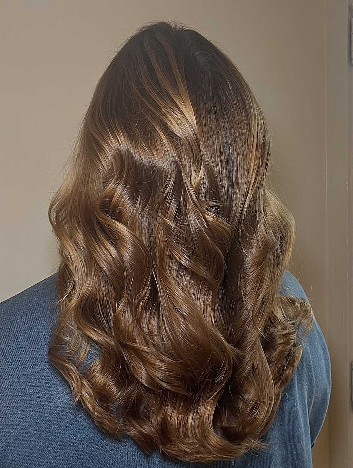 Brunette hair with glossy caramel balayage and curls