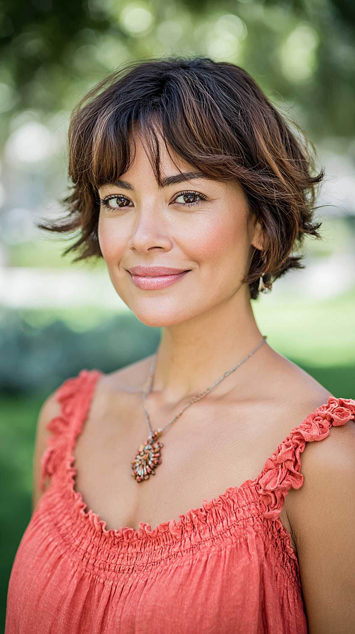 Short choppy brunette bob with wispy bangs and highlights
