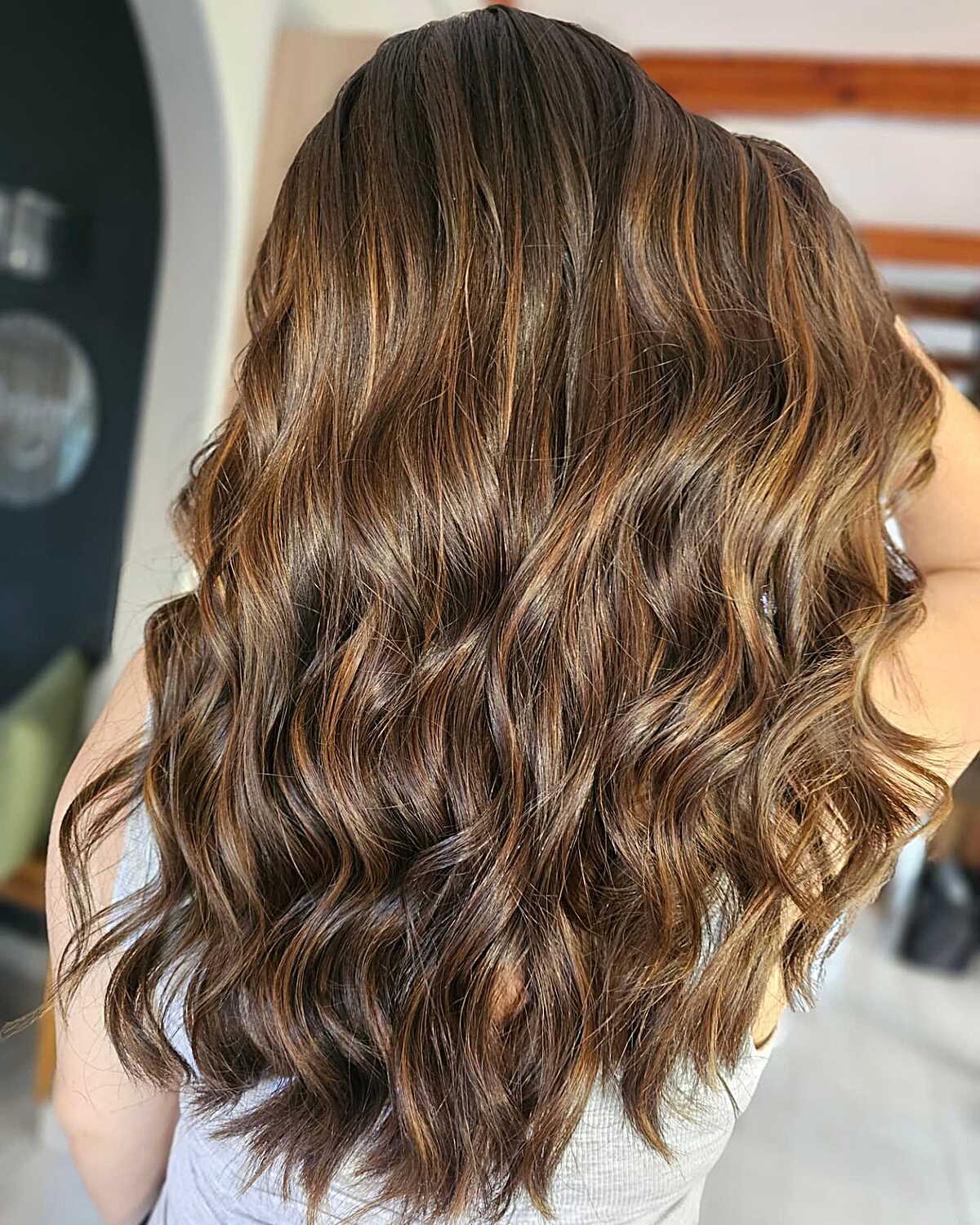 Brunette hair with golden caramel balayage in waves