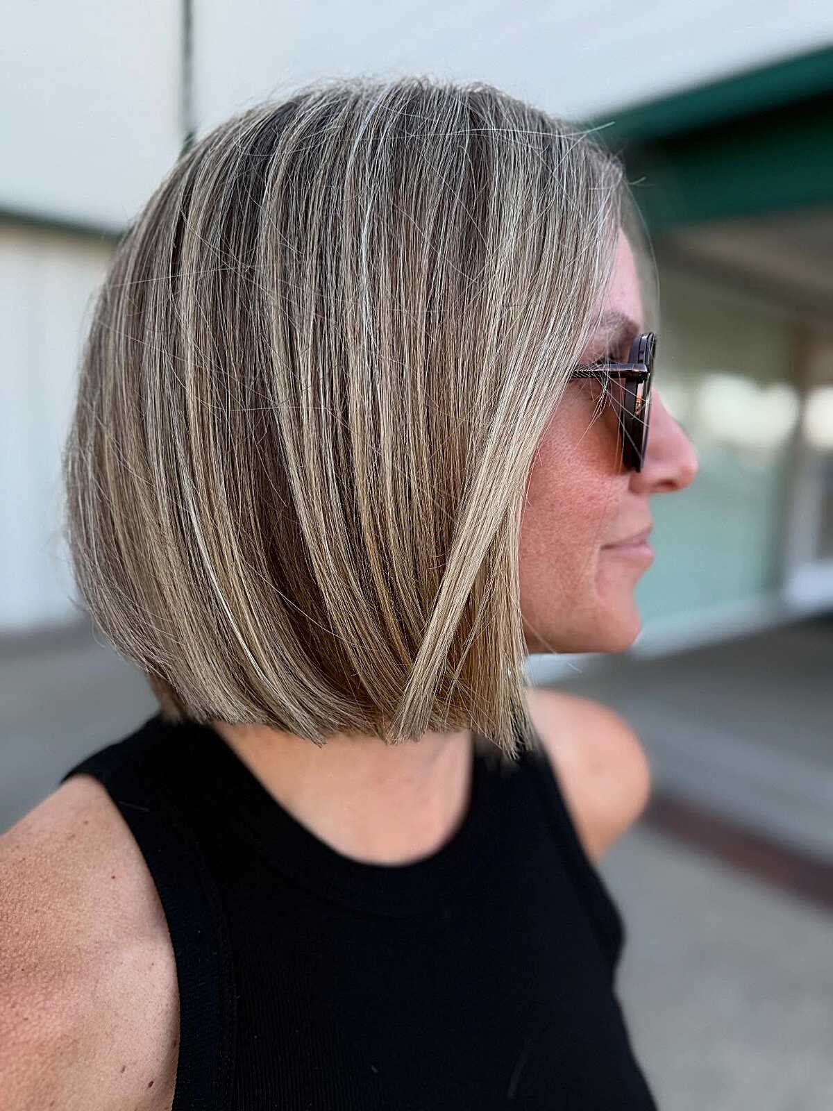 Angled straight bob with blonde highlights and sunglasses