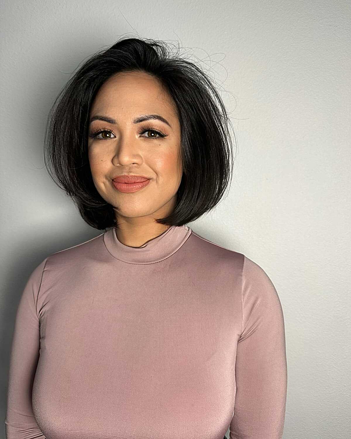 Jet black voluminous rounded bob with side part