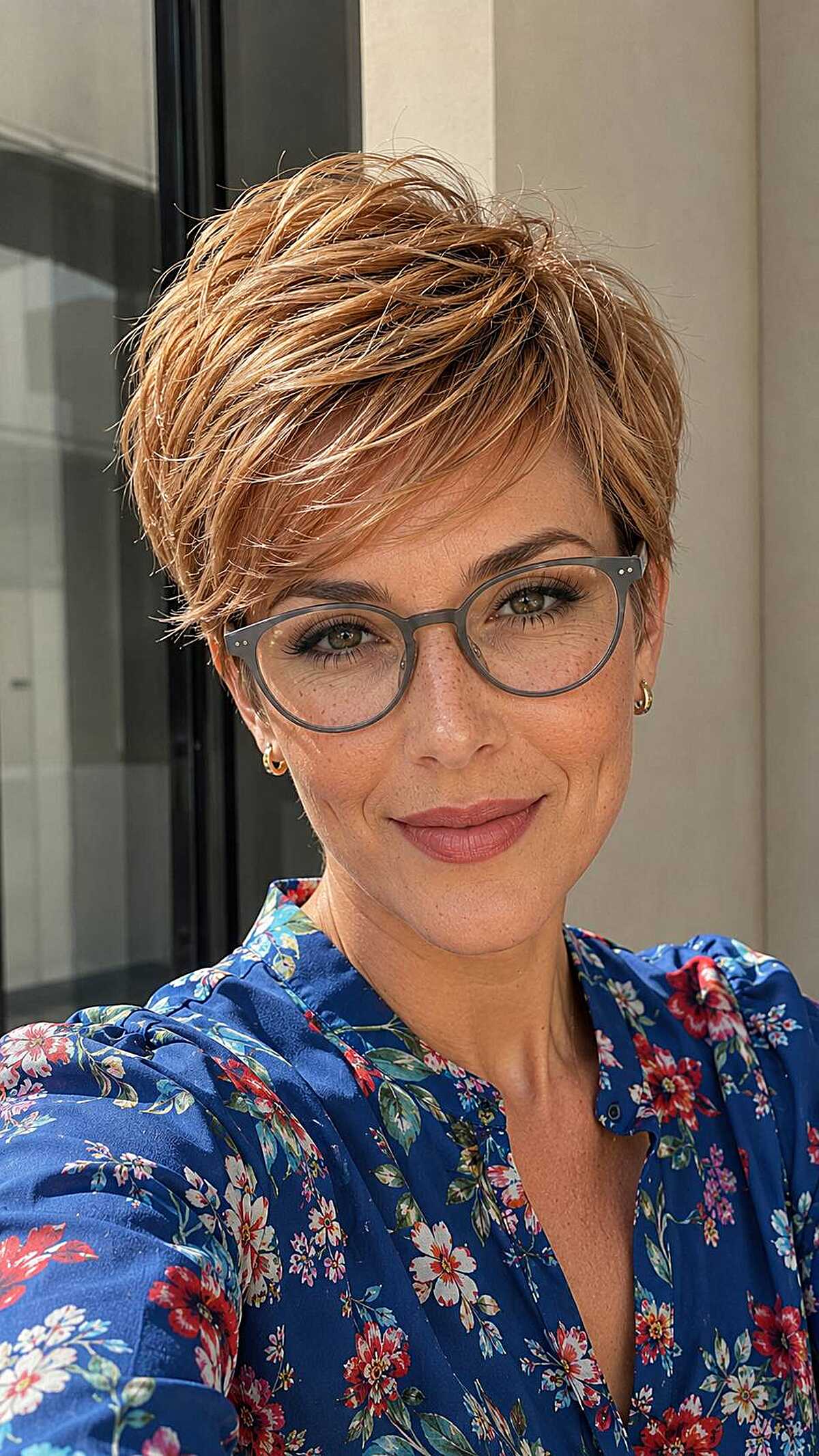 Strawberry blonde textured pixie with gray round frames