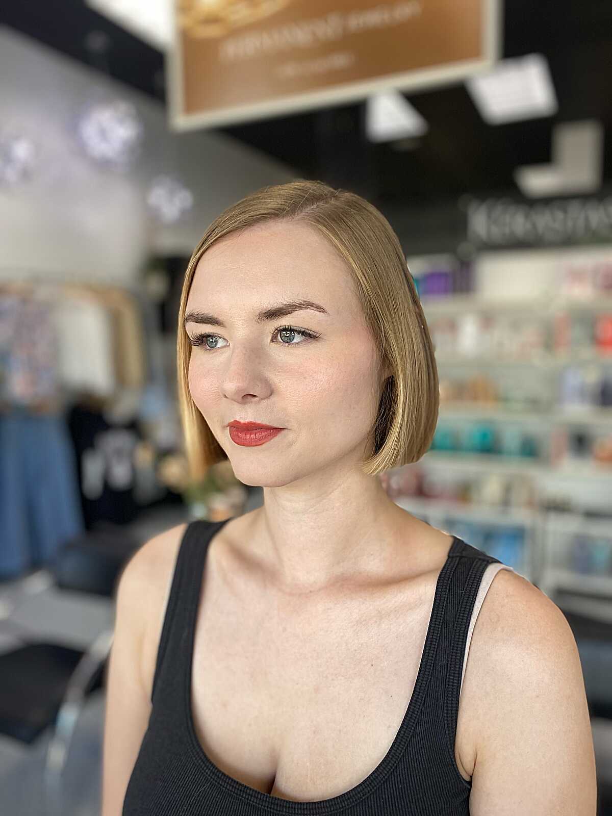 Sleek strawberry blonde chin-length bob with side part