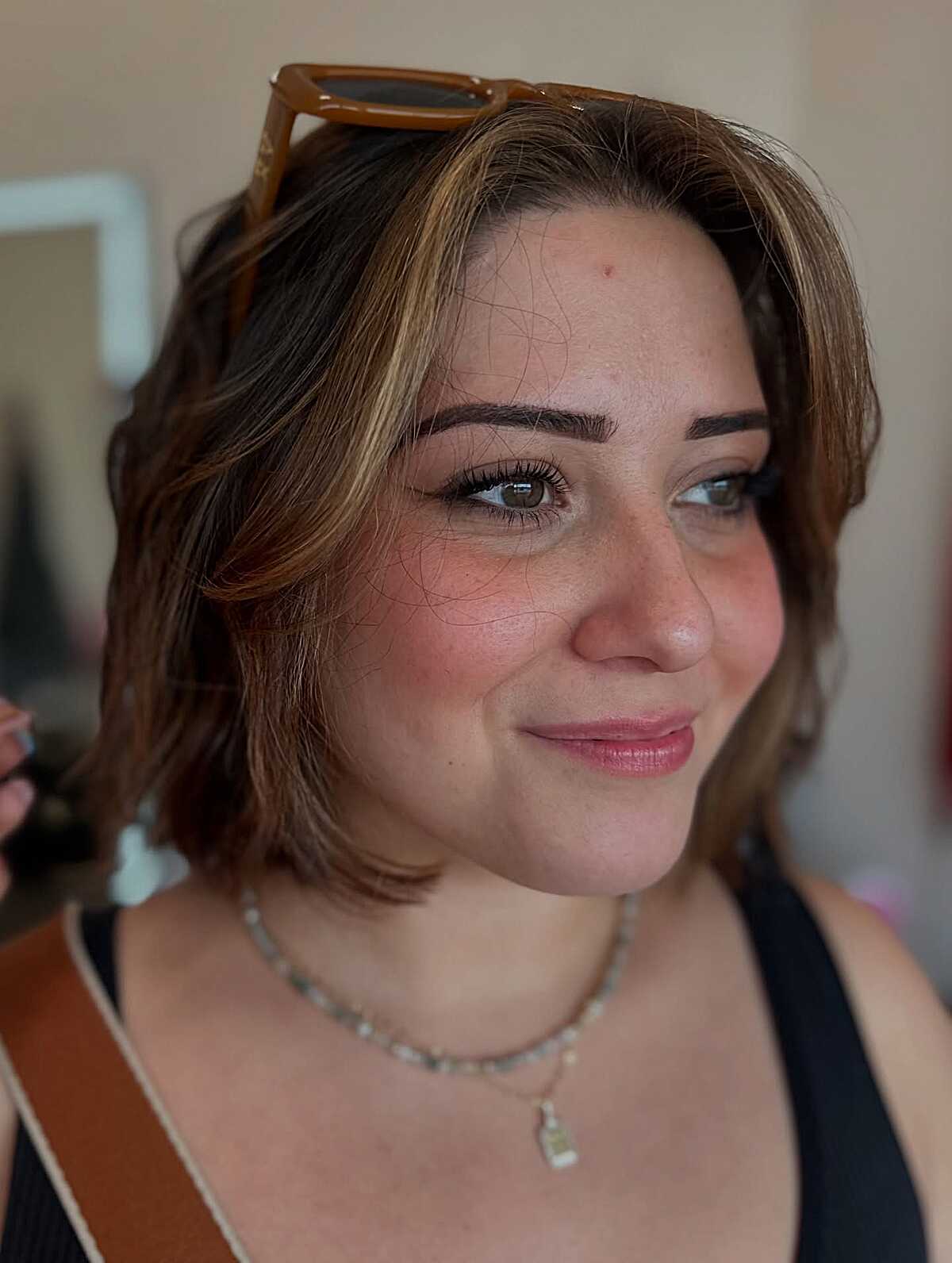 Short wavy brunette bob with warm highlights and texture