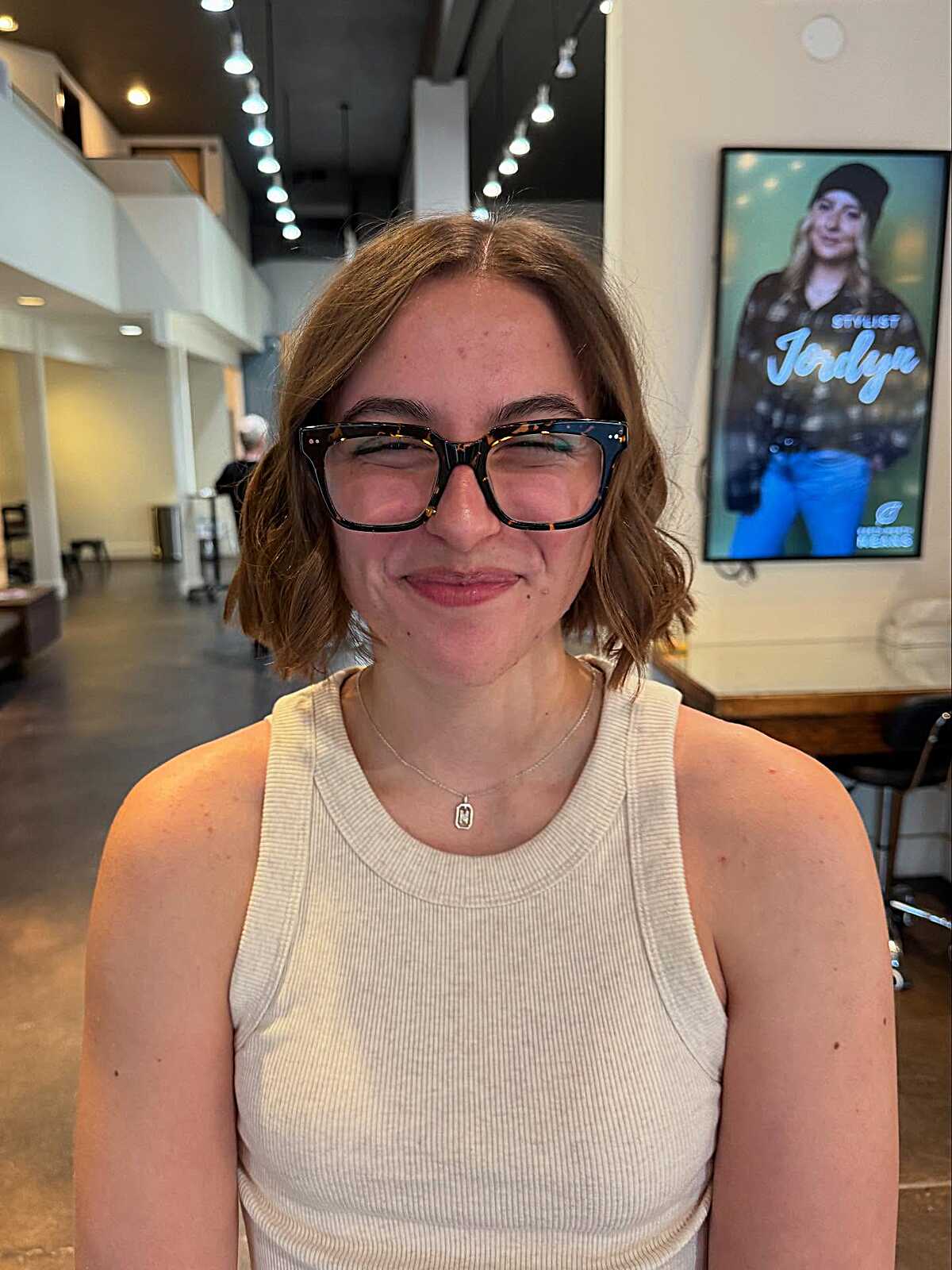 Short textured auburn wavy bob with oversized glasses