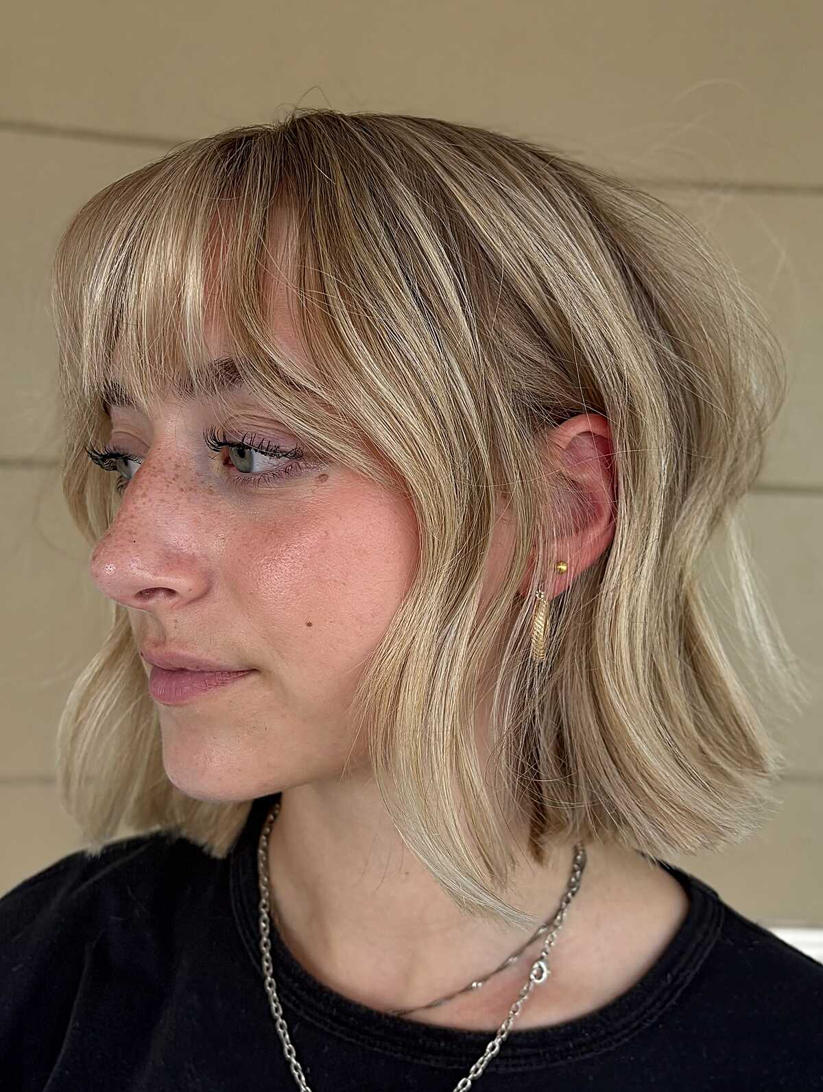 Choppy blonde bob with soft wispy bangs and texture