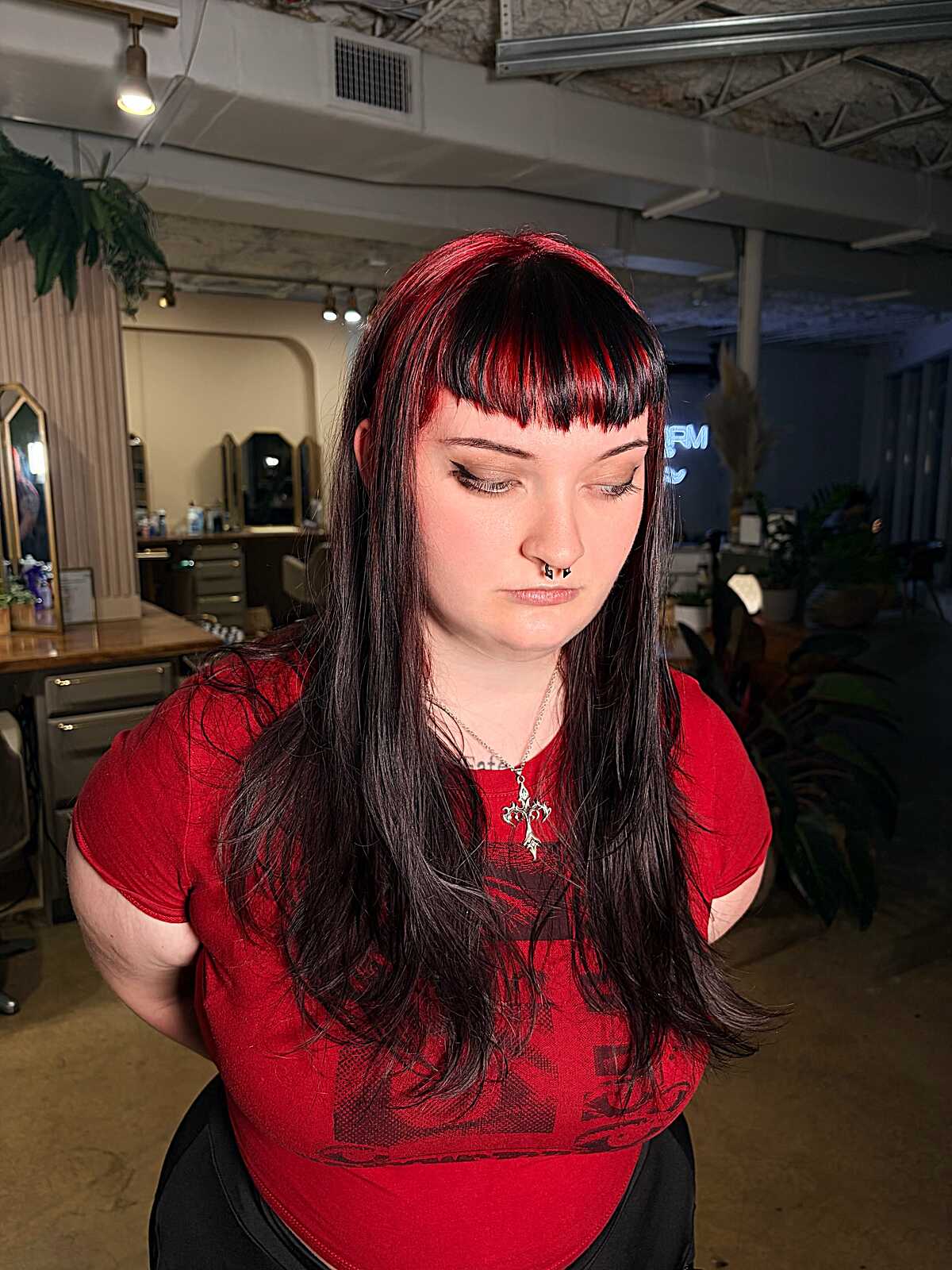 Long black hair with red streaks and blunt micro bangs