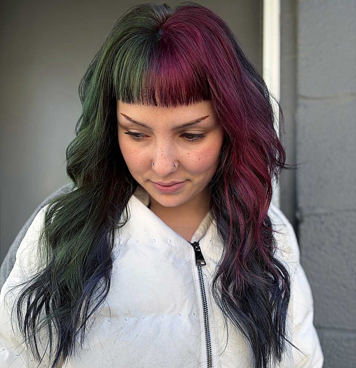 Split dye green and plum hair with short shaggy bangs
