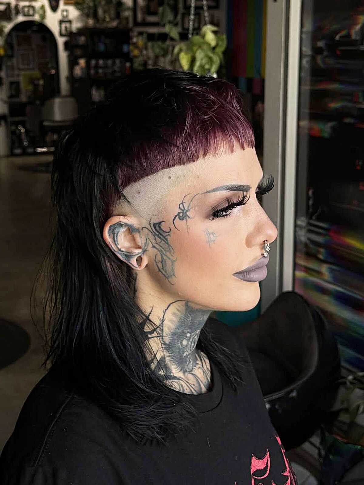 Black mullet with purple micro bangs and shaved sides
