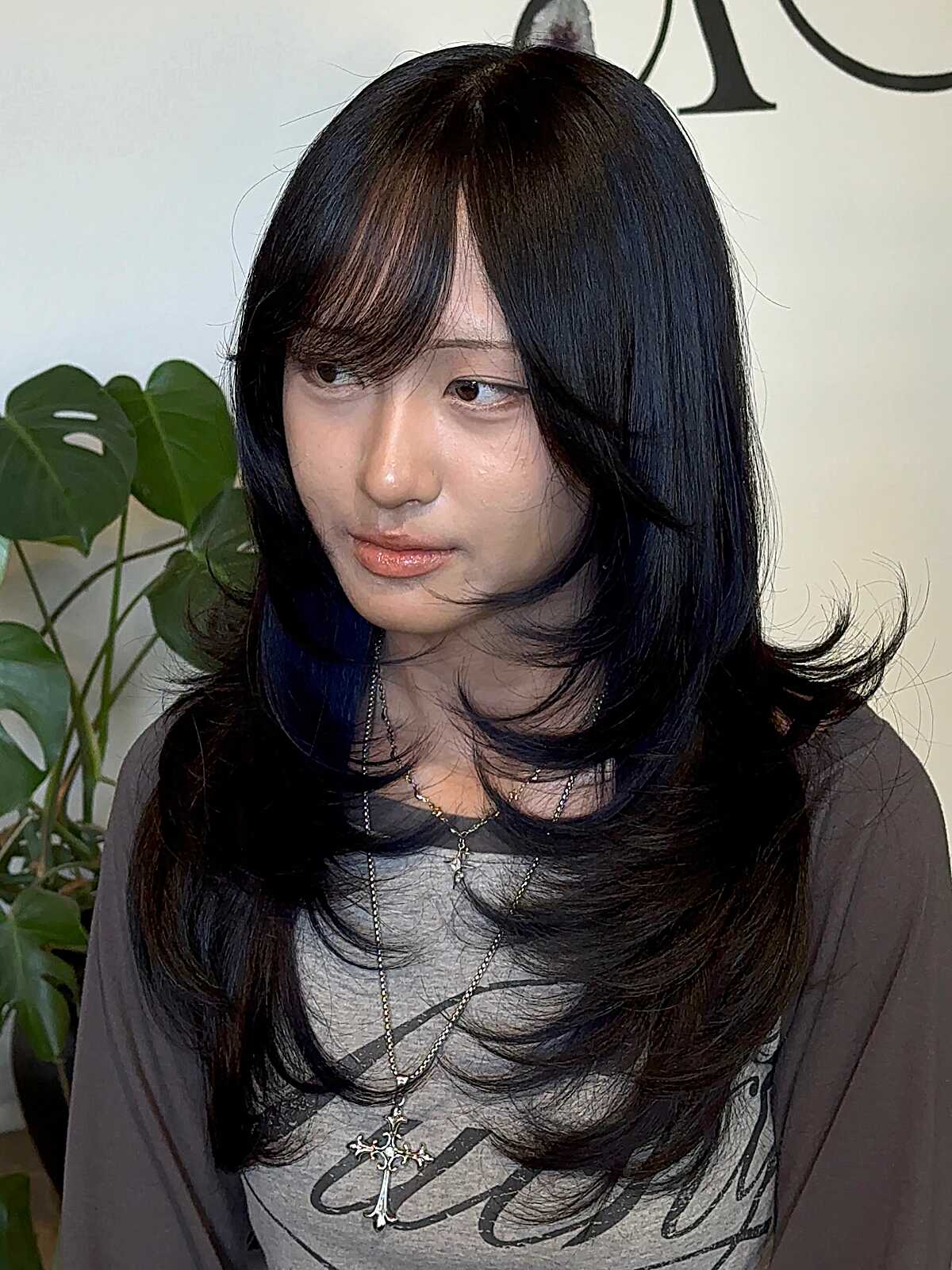 Long blue-black layered hair with curtain side bangs